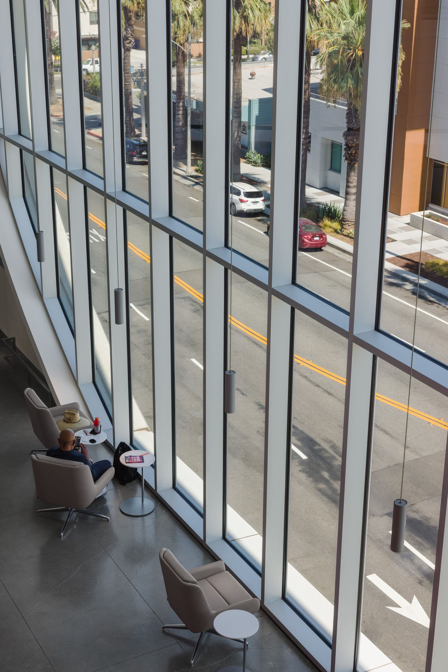 Detail of oblong shaped window from inside of the Riverside Main Library and a man reading.