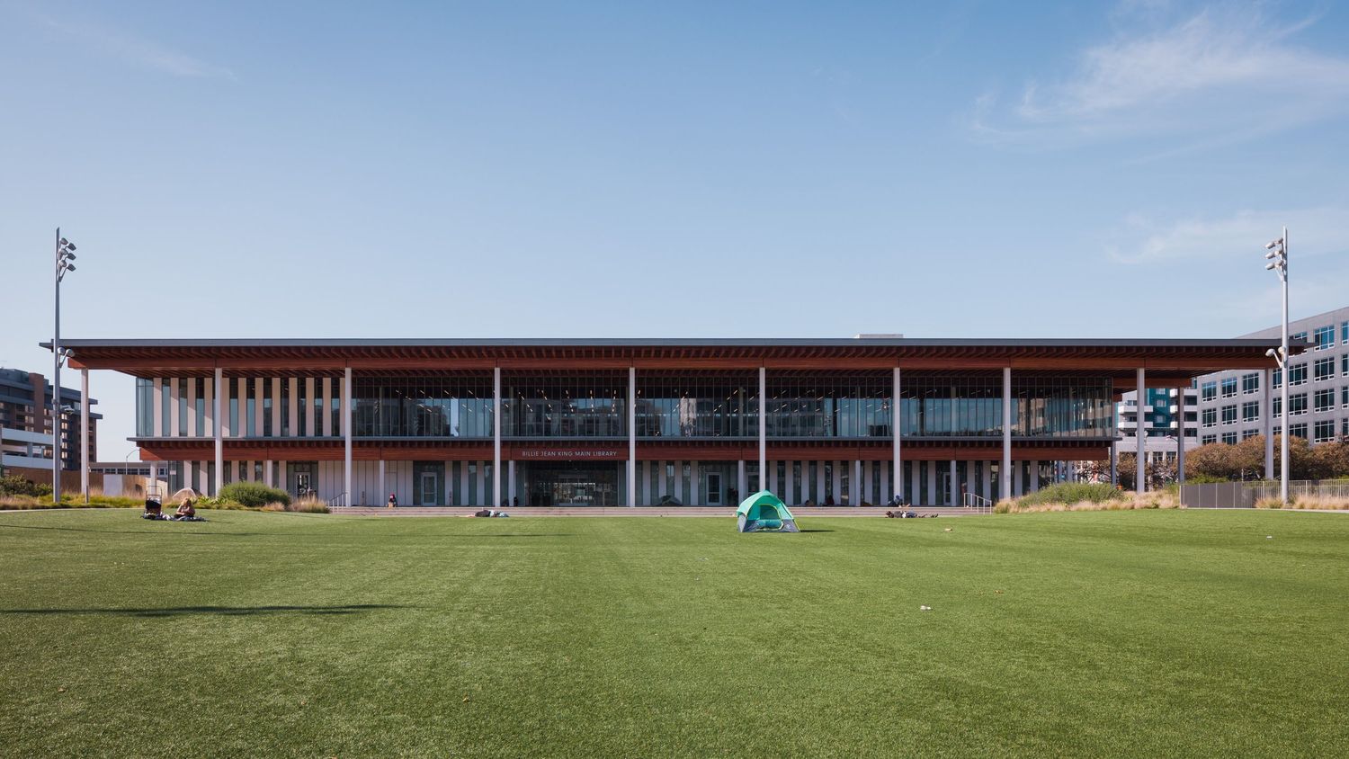 The Billie Jean King Main Library seen from the lawn with a tent on the grass