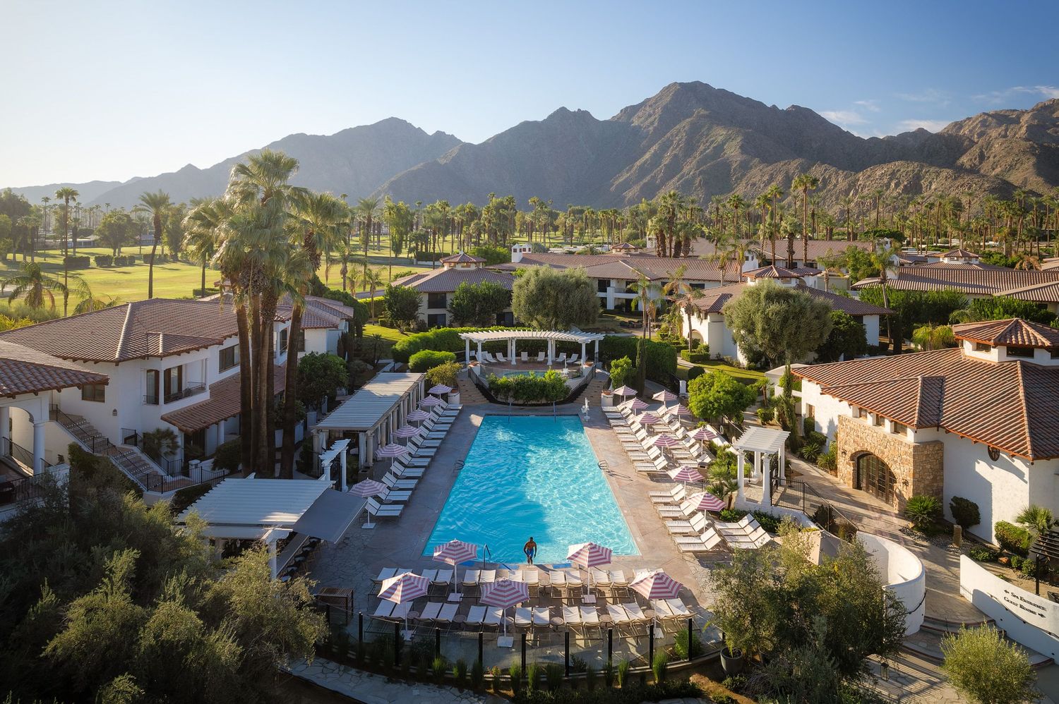 Aerial view of the pool at Tommy Bahama Miramonte Resort with a man emerging from one end