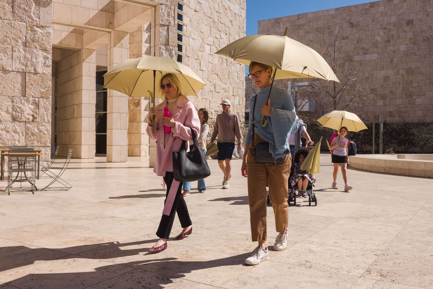 A group of people carrying umbrellas to shade from the sun at the Getty Center by Richard Meier in Los Angeles