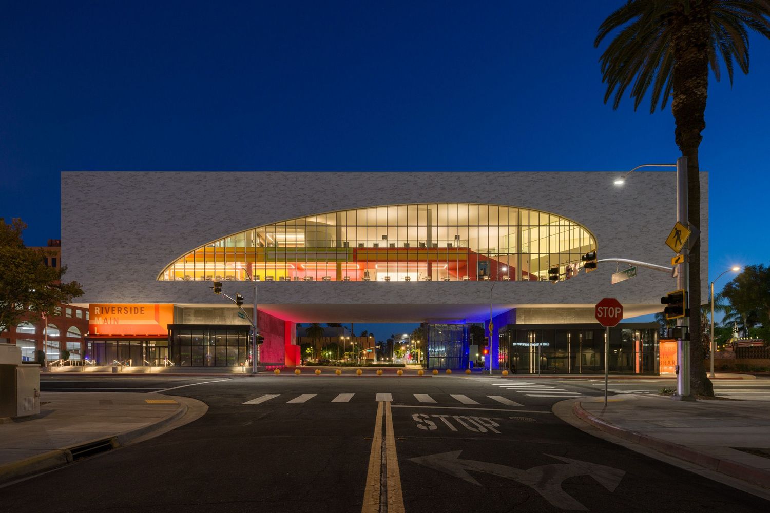 Front elevation of the Riverside Main Library illuminated from within at night just after dusk