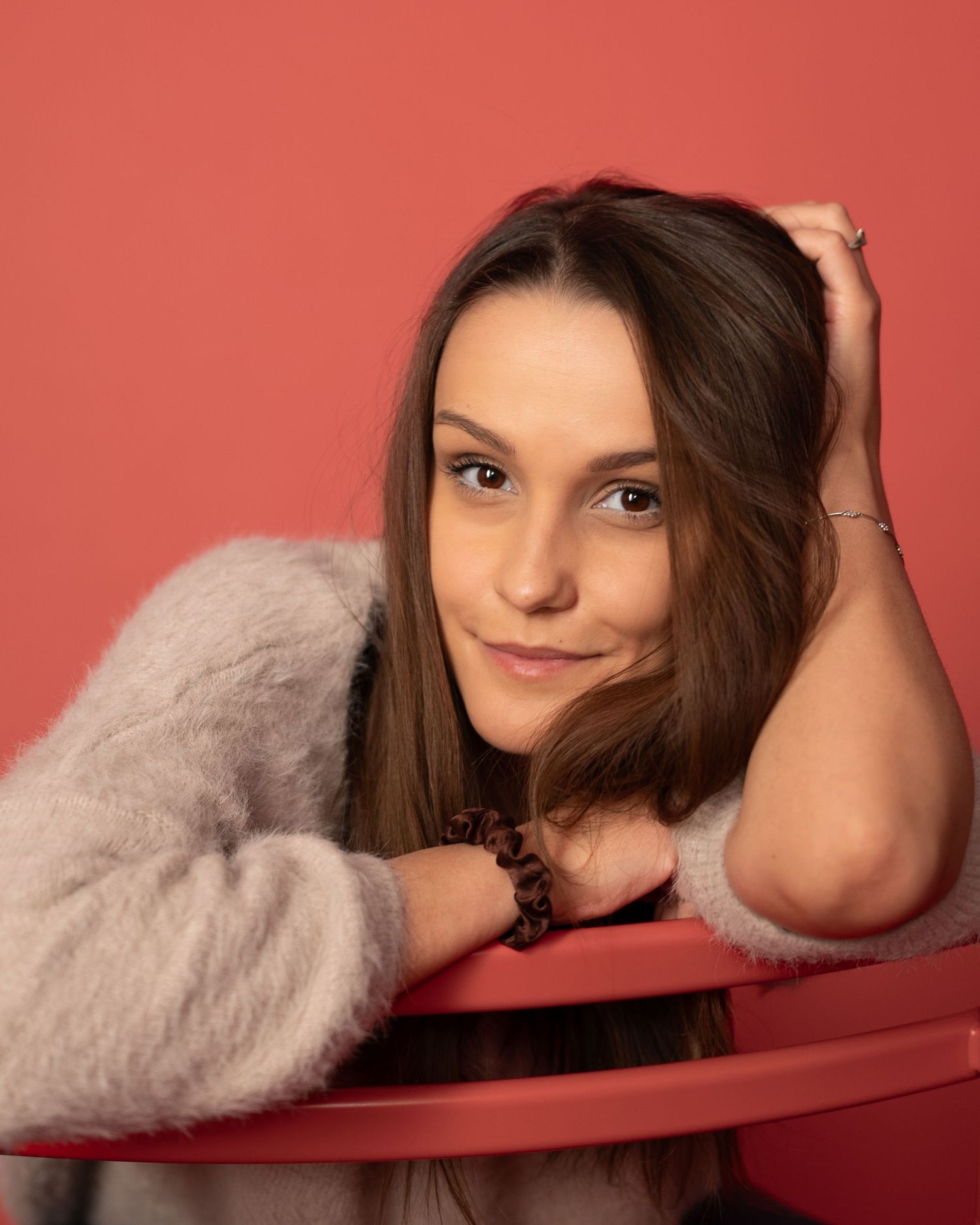 Portret dziewczyny na czerwonym tle, miękkie światło, ciepła kobieca sesja zdjęciowa w studio