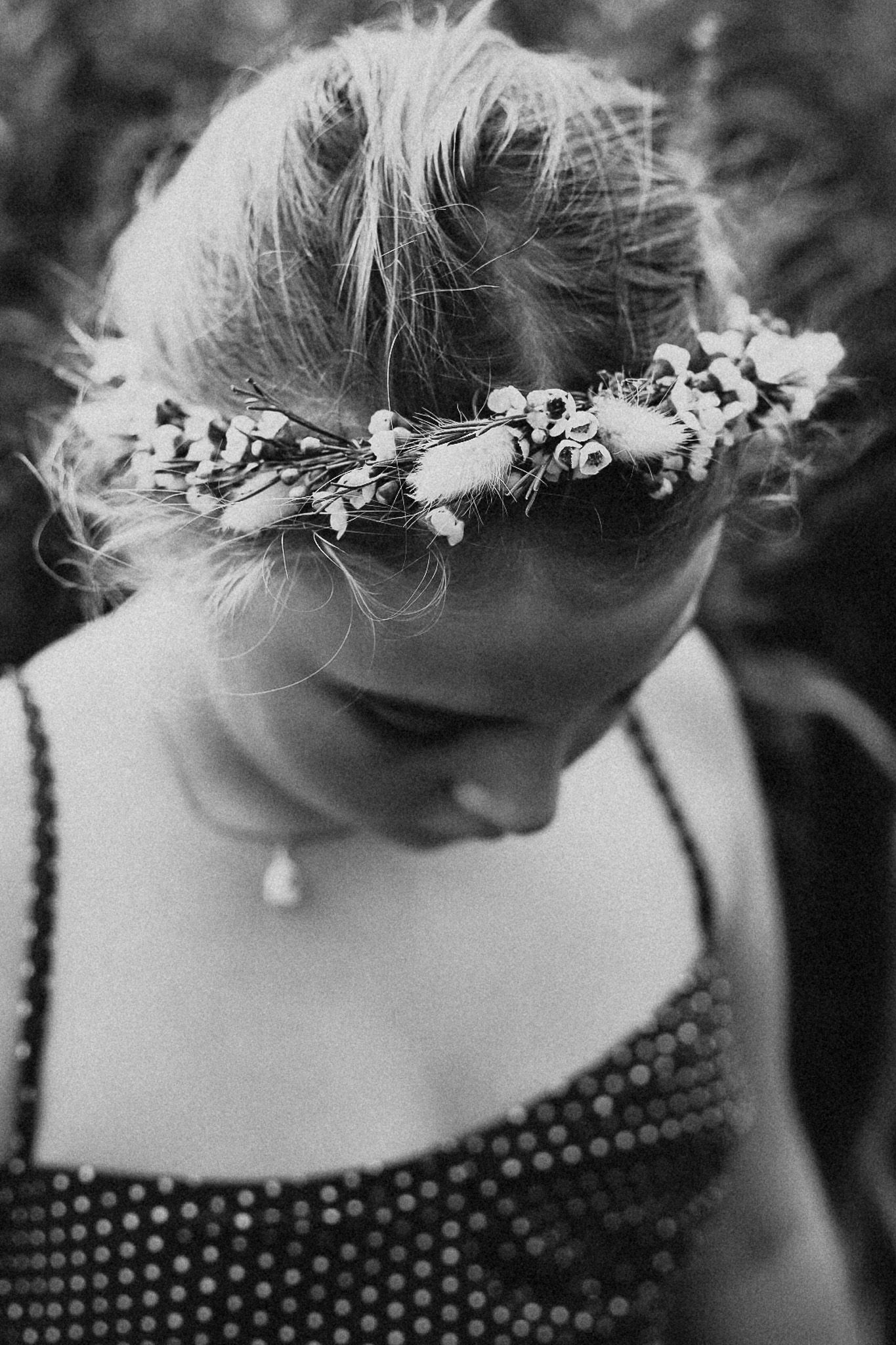 Black and white portrait of a young woman wearing a delicate floral crown.