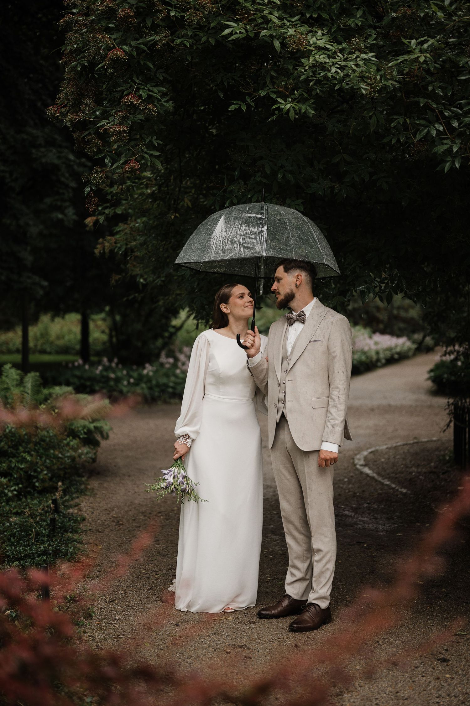 Nuotaka ir jaunikis gamtoje su skėčiu – natūrali vestuvių fotografija