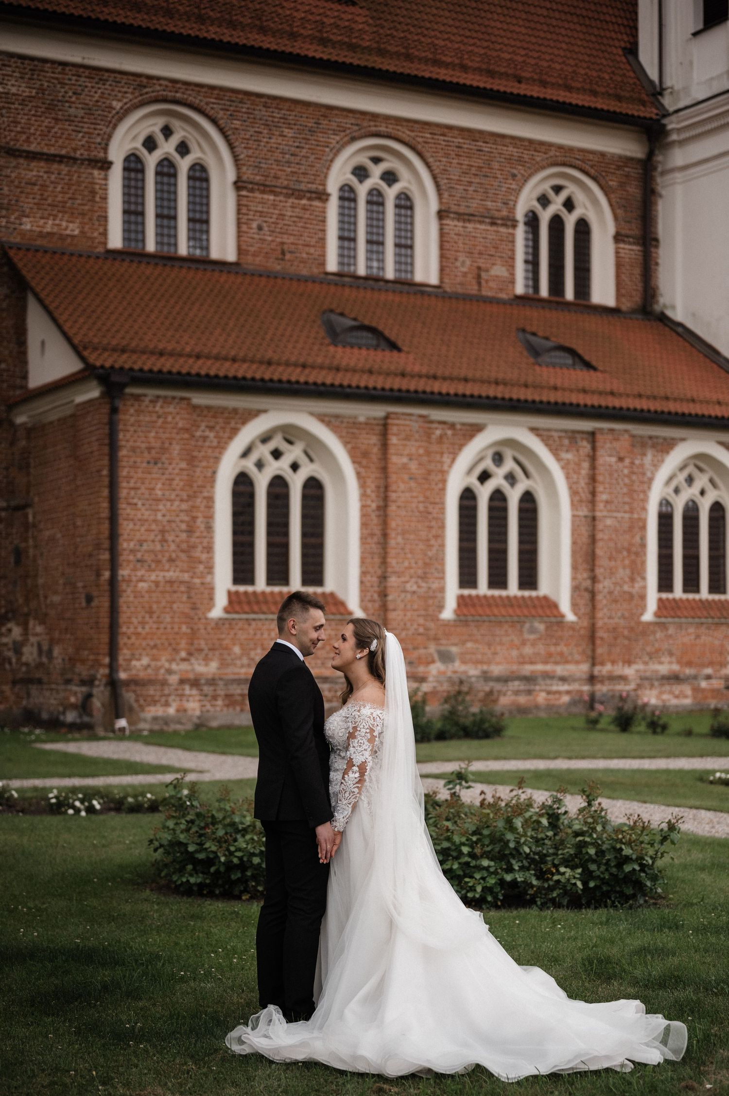 Nuotaka ir jaunikis prie bažnyčios – klasikinė vestuvių fotografija