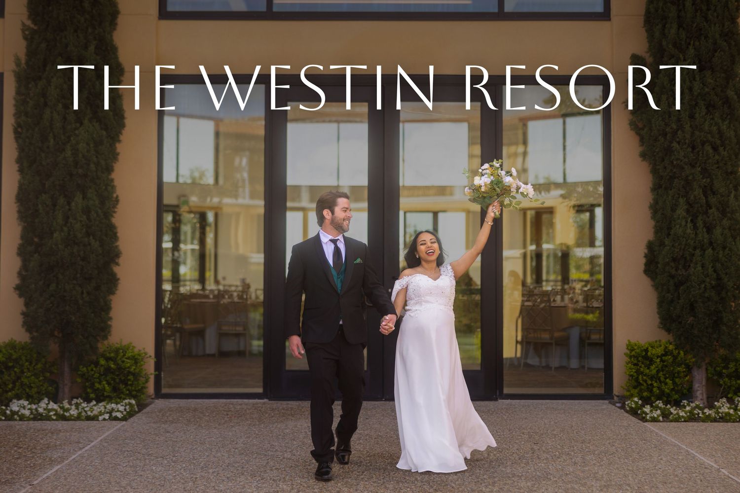 Newlywed couple walks hand in hand outside entrance of The Westin Resort on their wedding day.