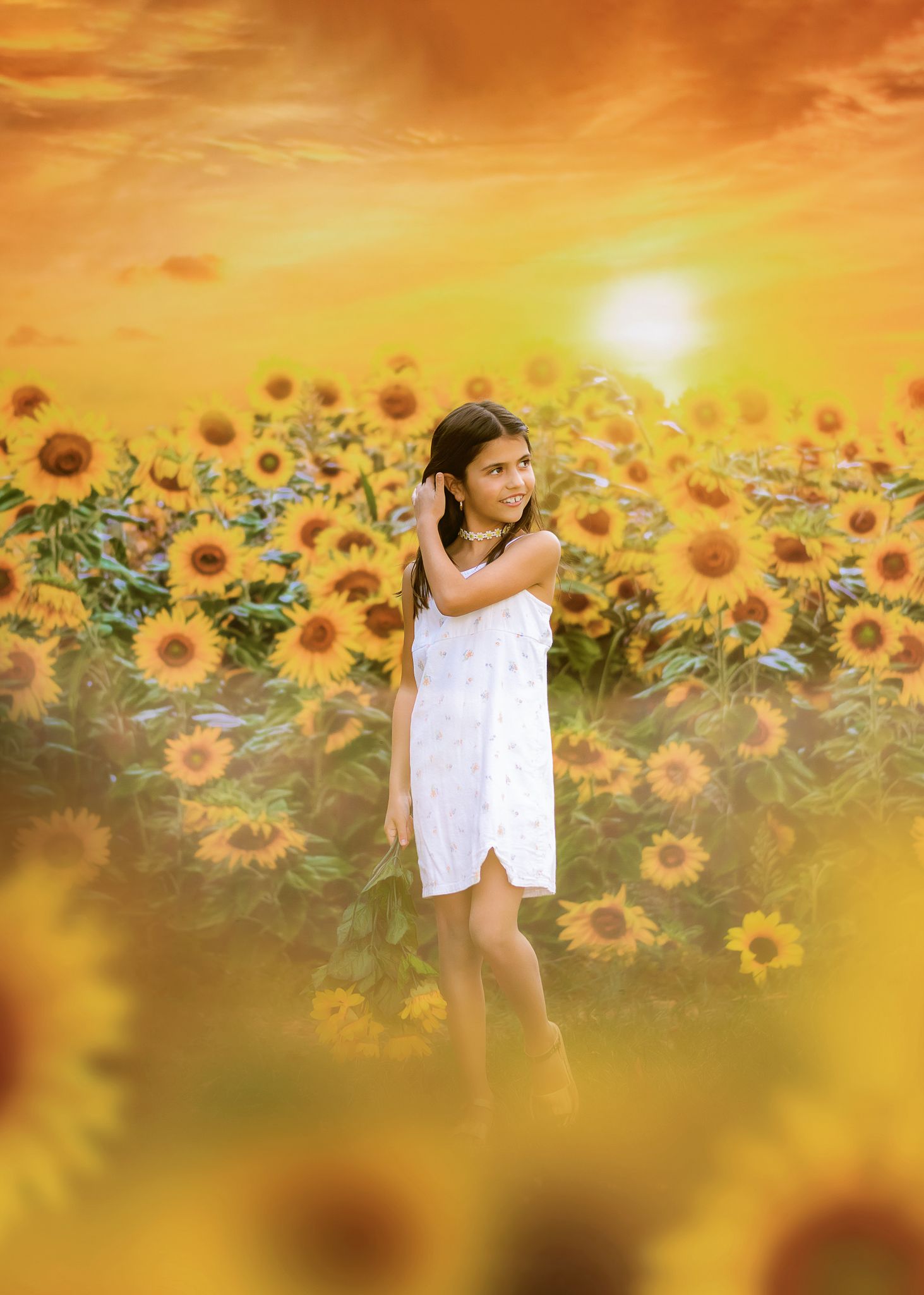 A dreamy golden sunset illuminates a field of bright sunflowers with blurred edges creating a magical summer atmosphere.