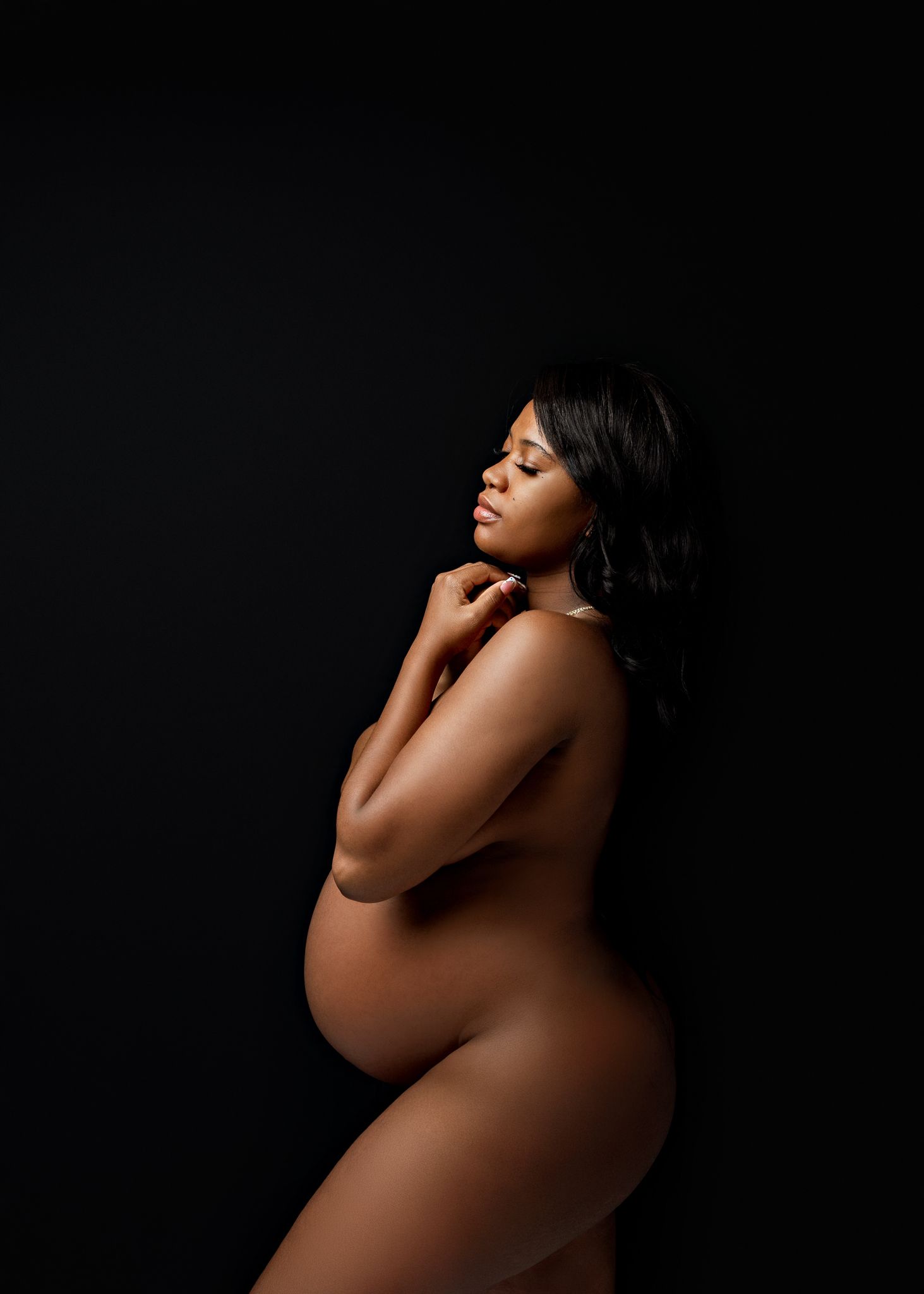 Artistic maternity silhouette series against black background showing pregnant figure in graceful poses.