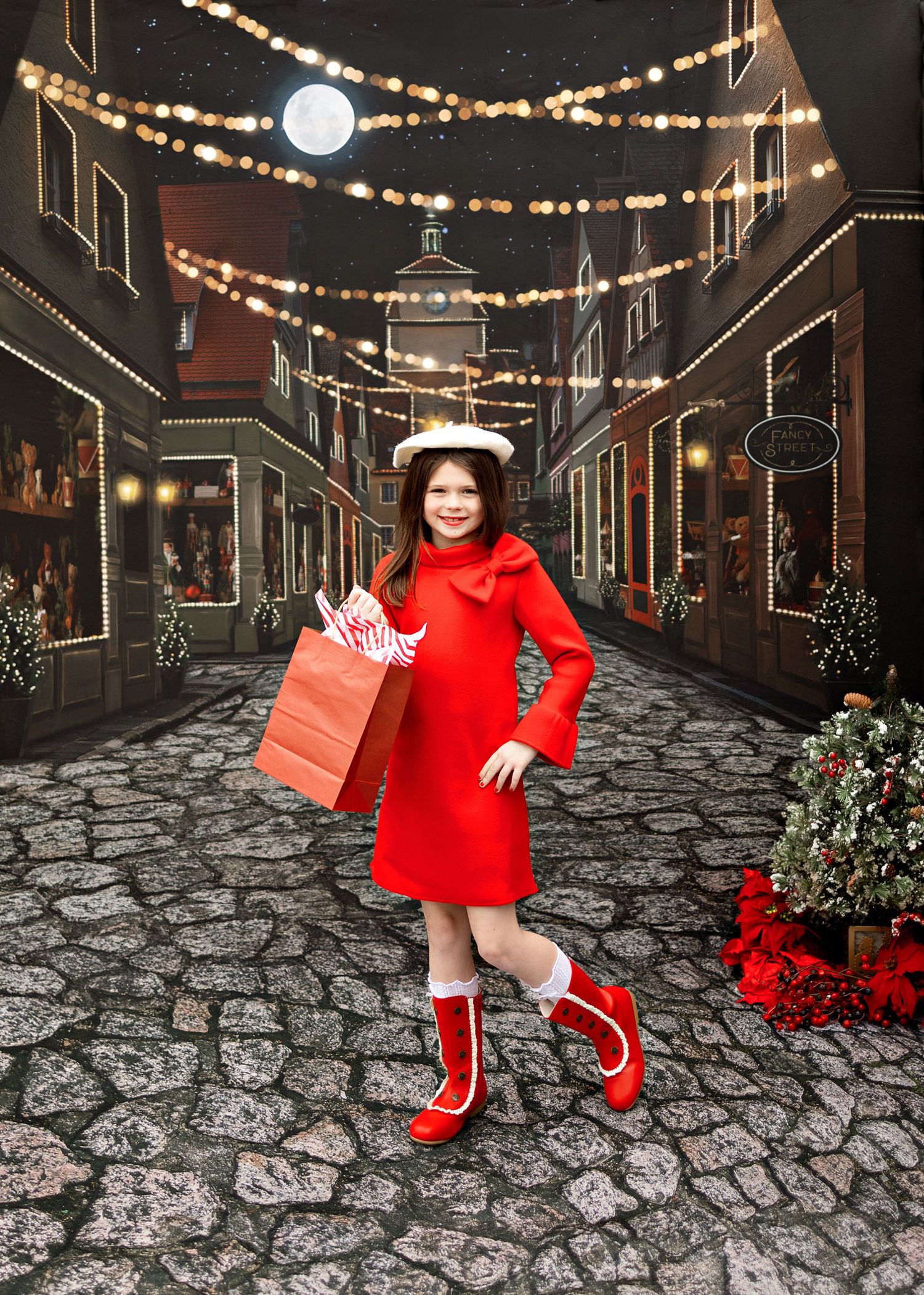 Person in bright red sweater and white boots walks down a charming cobblestone street decorated with festive string lights.