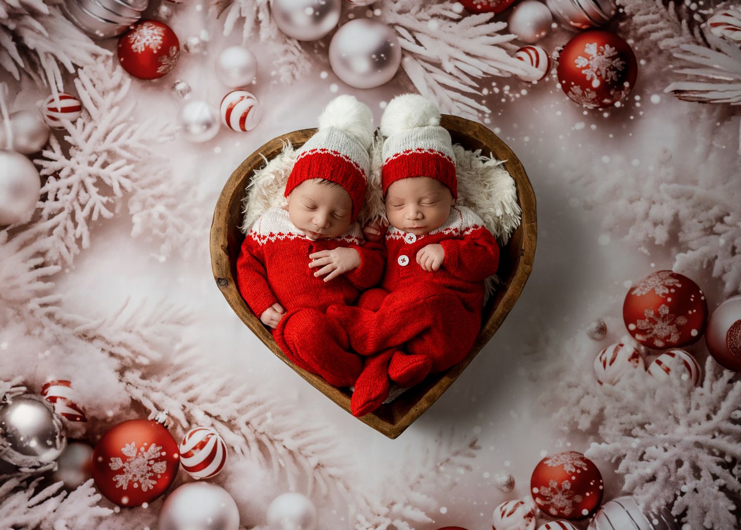 Red and white Christmas ornaments with sparkly decorations arranged on snowy white background.
