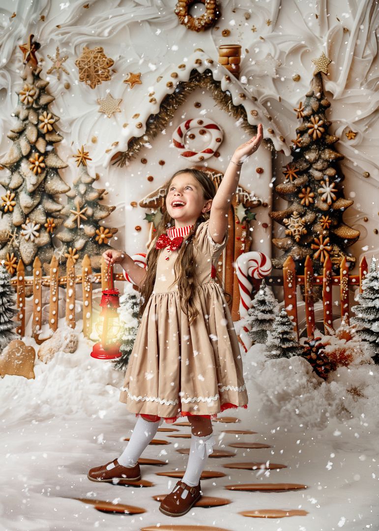 A joyful girl in a tan dress holds a lantern amid a whimsical snowy gingerbread Christmas scene.
