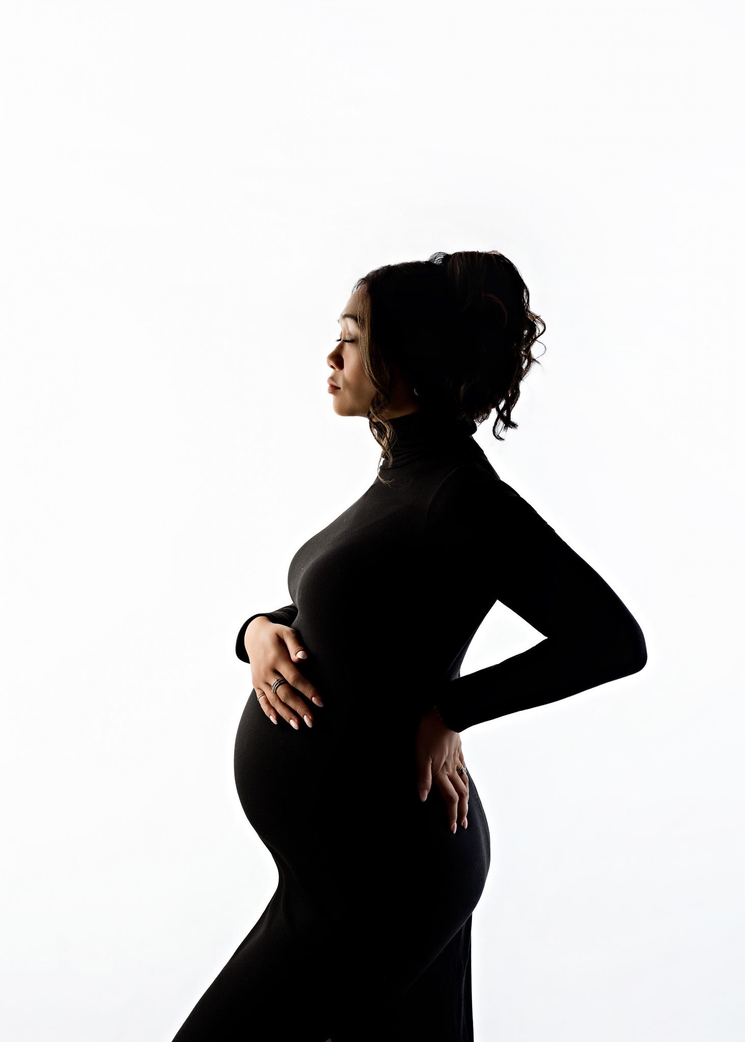 A series of silhouettes showing the progression of pregnancy from early stages to full term against a white background.