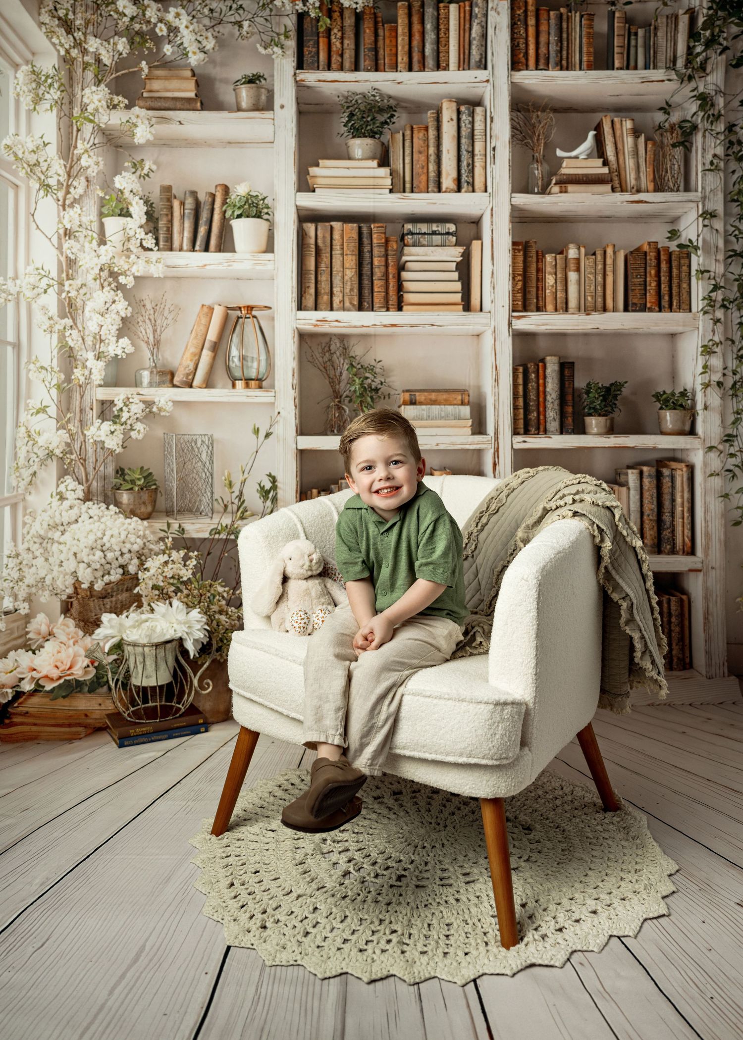 A cozy reading nook with built-in bookshelves, white decor, and a comfortable armchair on a rustic wooden floor.