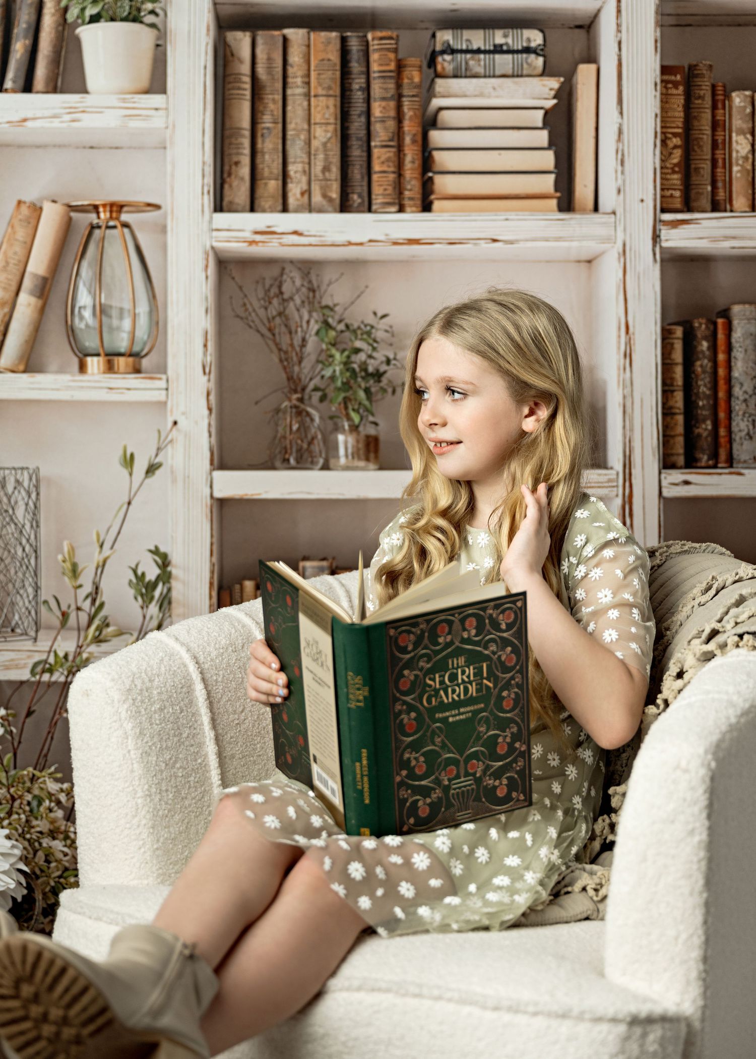 A cozy reading nook with white armchairs, vintage books on shelves, and natural light streaming through the window.