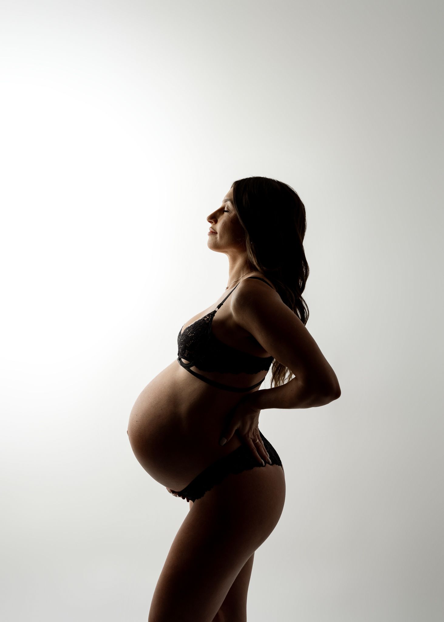 A series of silhouetted maternity photos showing a pregnant figure in profile against a light background.