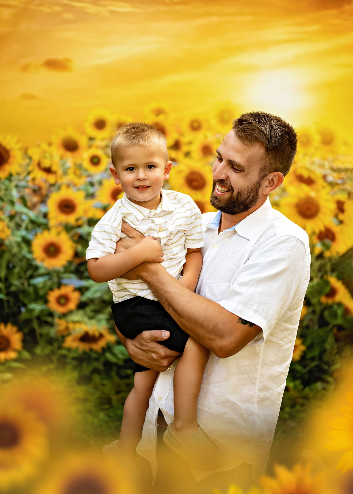 Father and son sharing a special moment in front of blooming sunflower field under golden sunset sky.