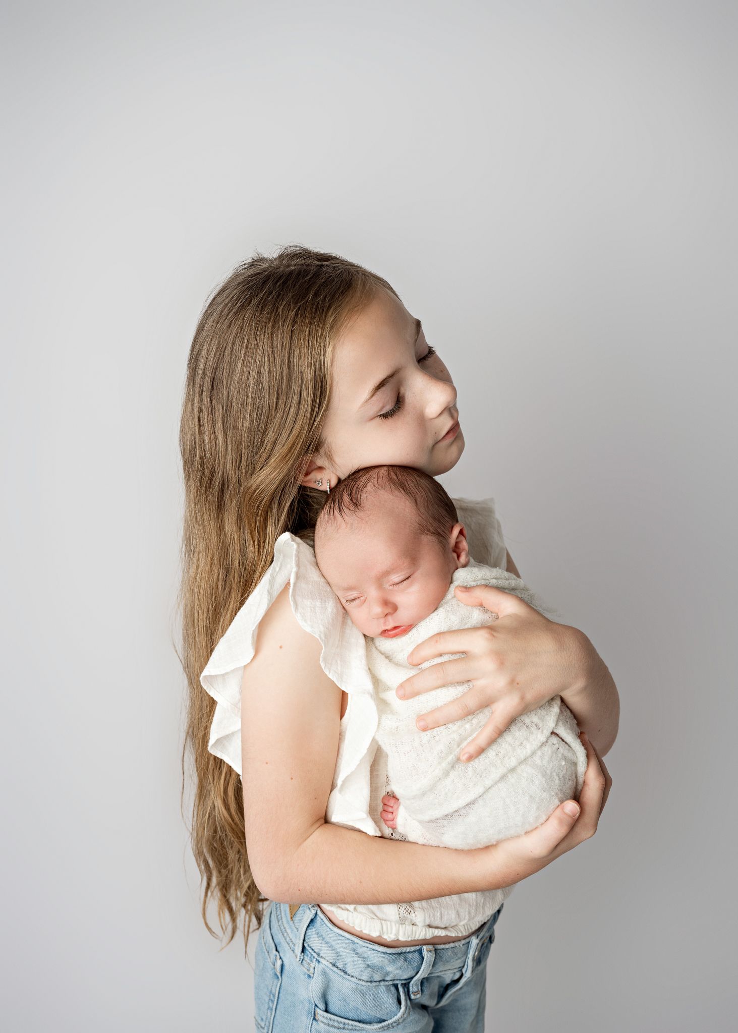 A series of four connected photos showing a tender embrace against a light gray background.