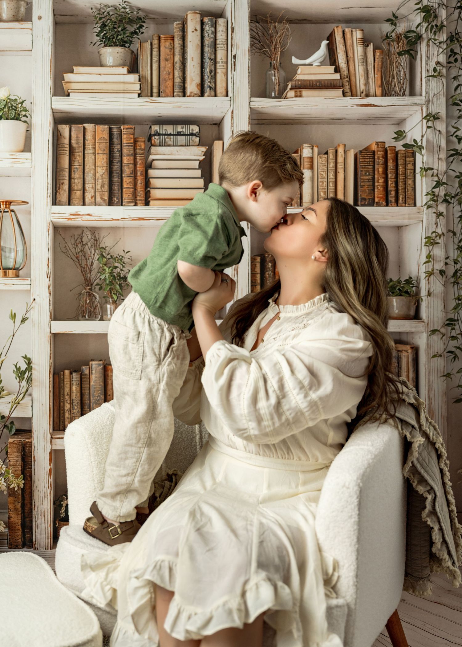 Vintage-style photo of someone in white clothing drinking from teacups on white shelves filled with antique books.