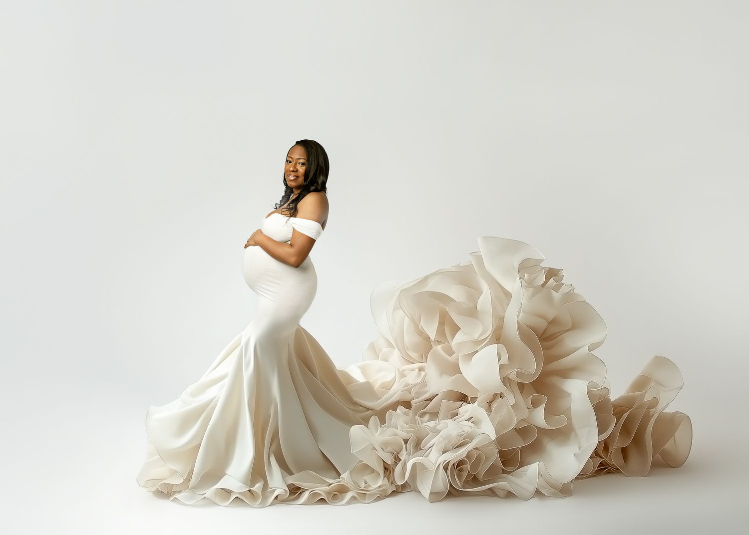 A figure in an elegant off-shoulder white mermaid wedding dress with cascading ruffles poses against a light background.