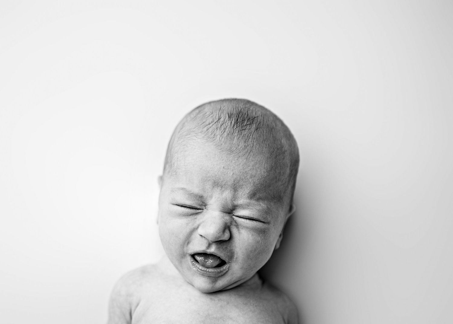 Black and white artistic portrait of a sleeping newborn baby in soft natural light.