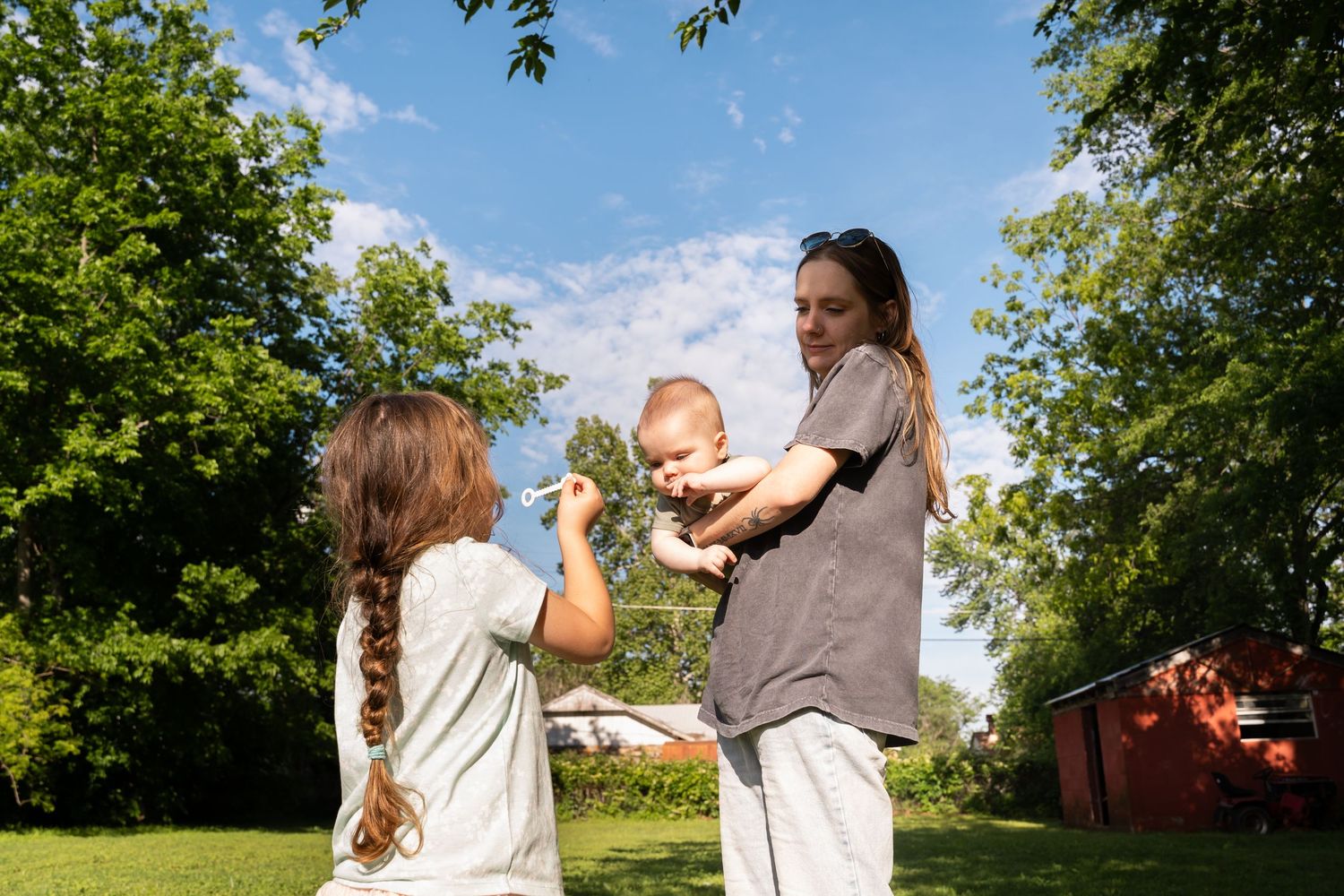 Photographer captures Mom and kids blowing bubbles together in Family Documentary Session in Tulsa, Oklahoma