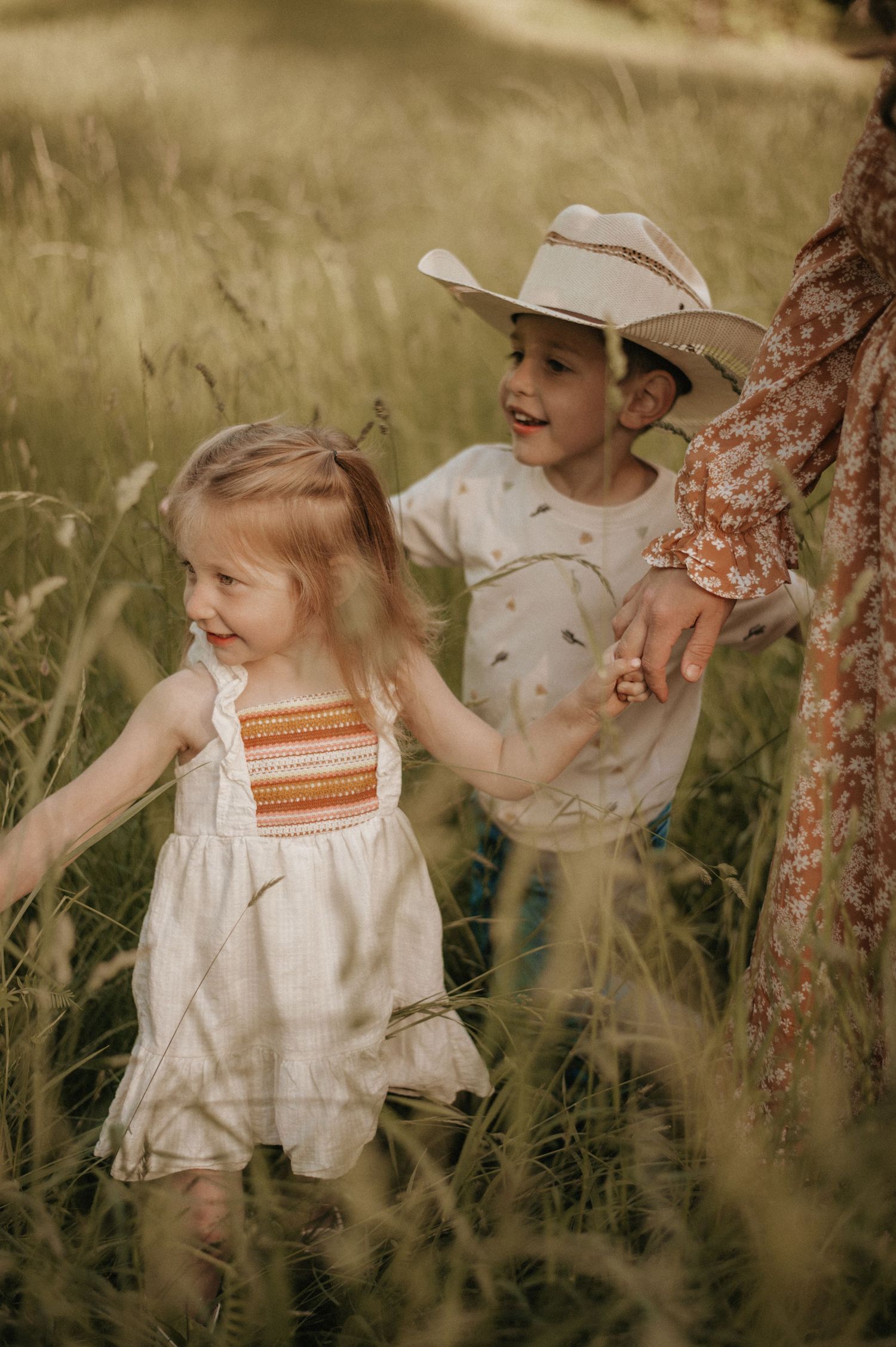Joyful children’s photography in a golden hay field in Maine, capturing carefree moments, laughter, and the magic of childhood.