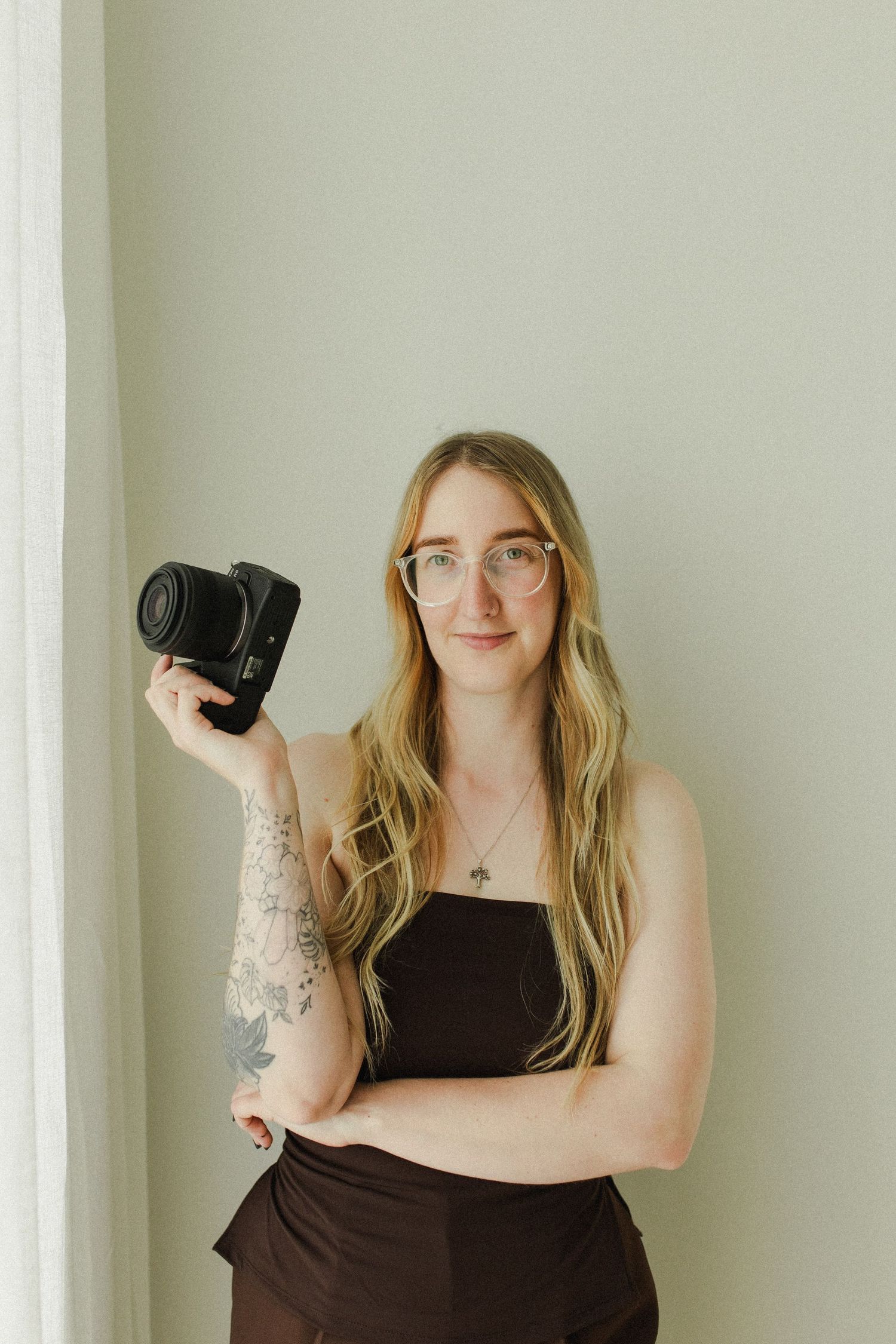 Woman wearing glasses holding a camera