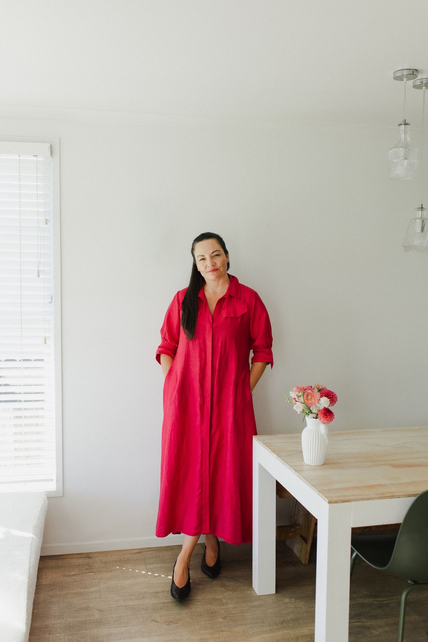 Female business owner with hands on hips smiling at camera during branding photography session