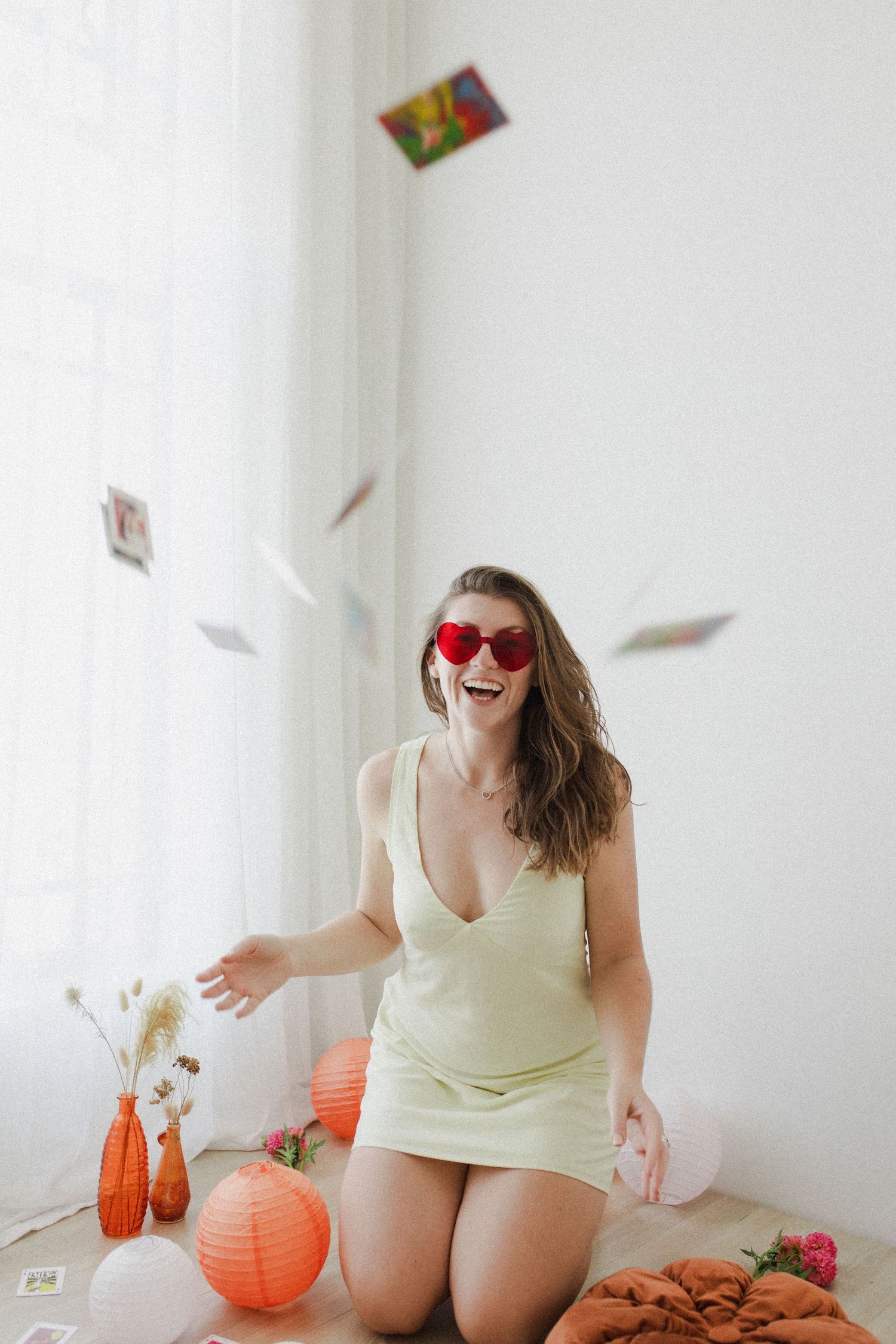 Woman laughing while throwing up photos in the air