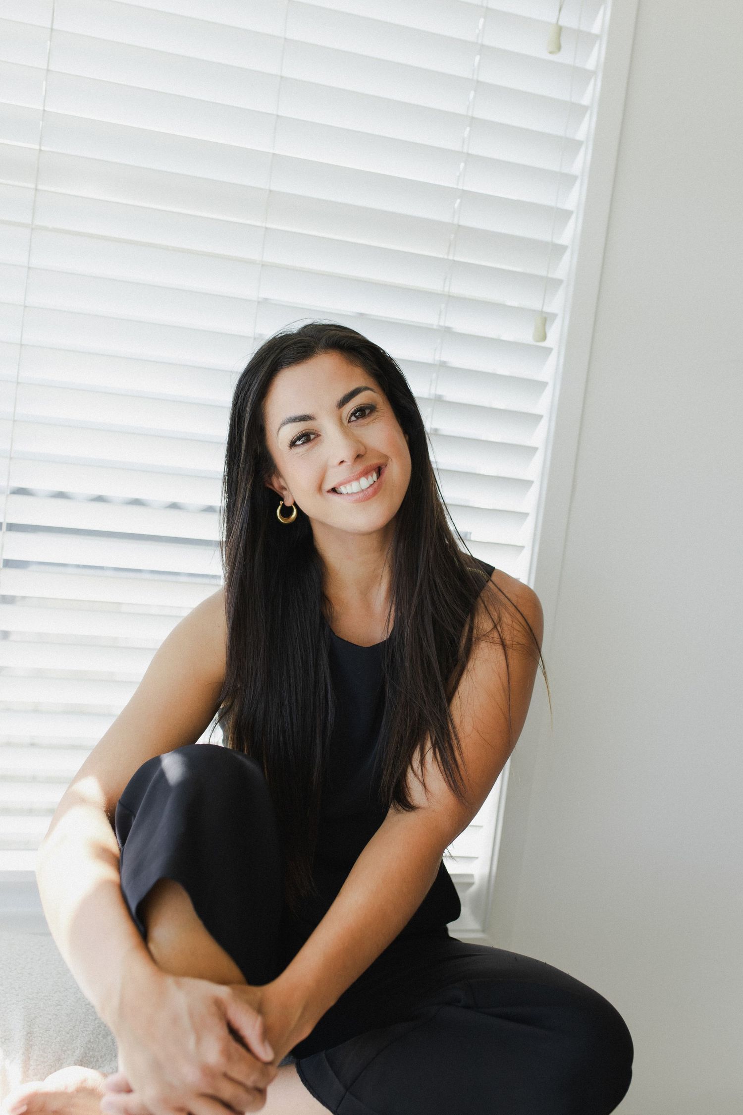 Woman seated smiling at camera during personal branding photoshoot