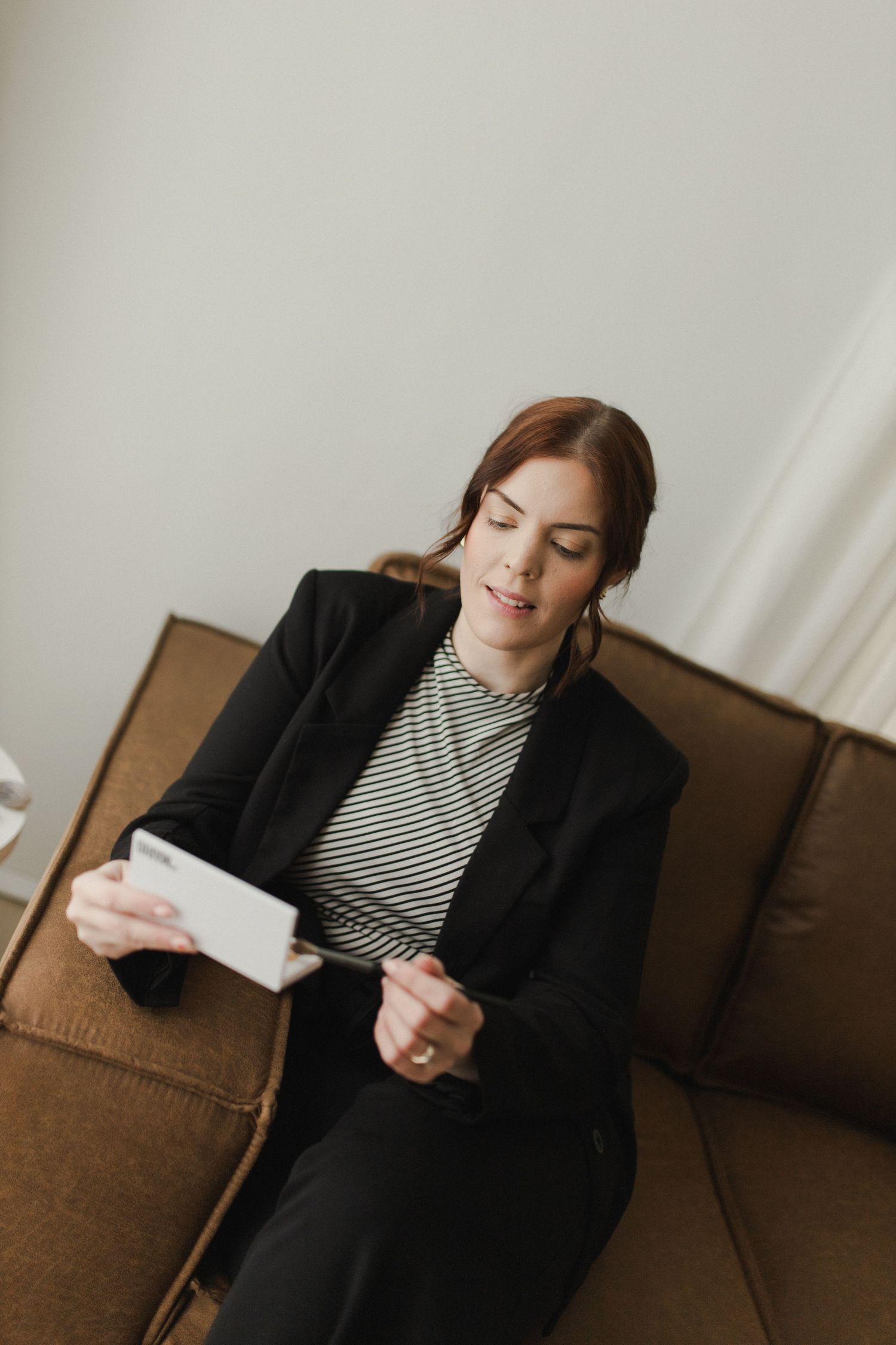 Woman sitting on couch during branding photoshoot in Hamilton studio
