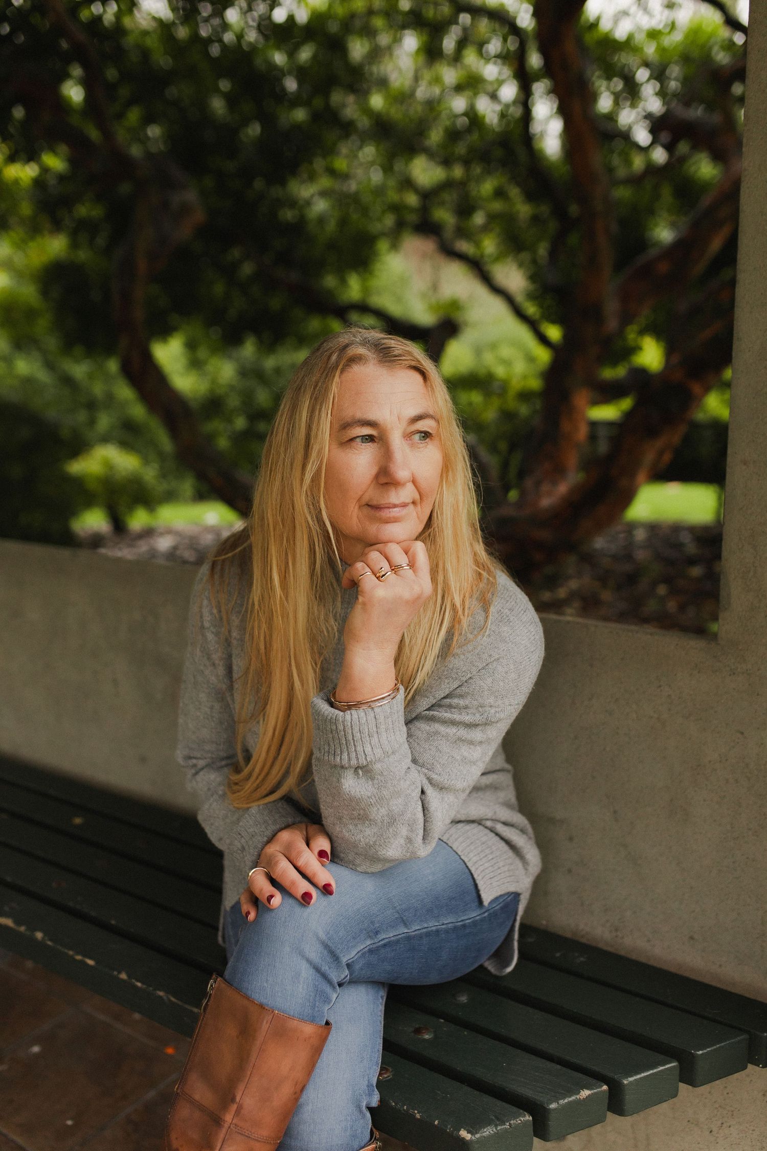 Woman looking thoughtful while sitting on a bench in a park