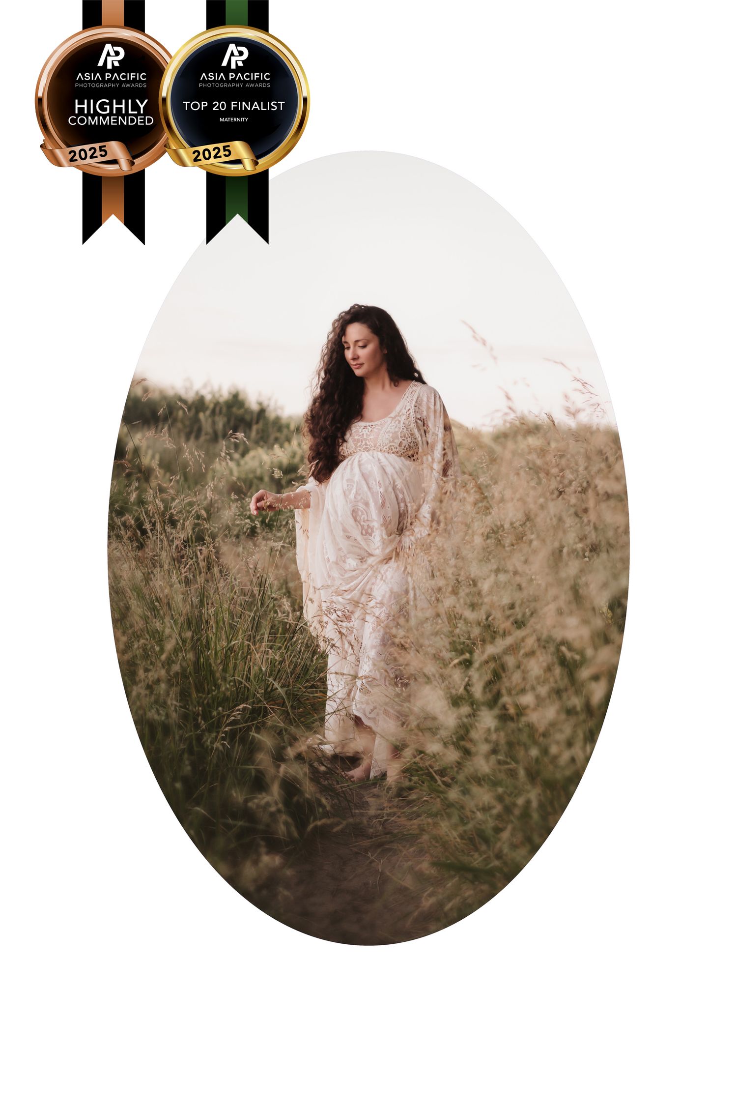 A person in a flowing white lace dress stands gracefully in a sun-lit meadow of tall grass.