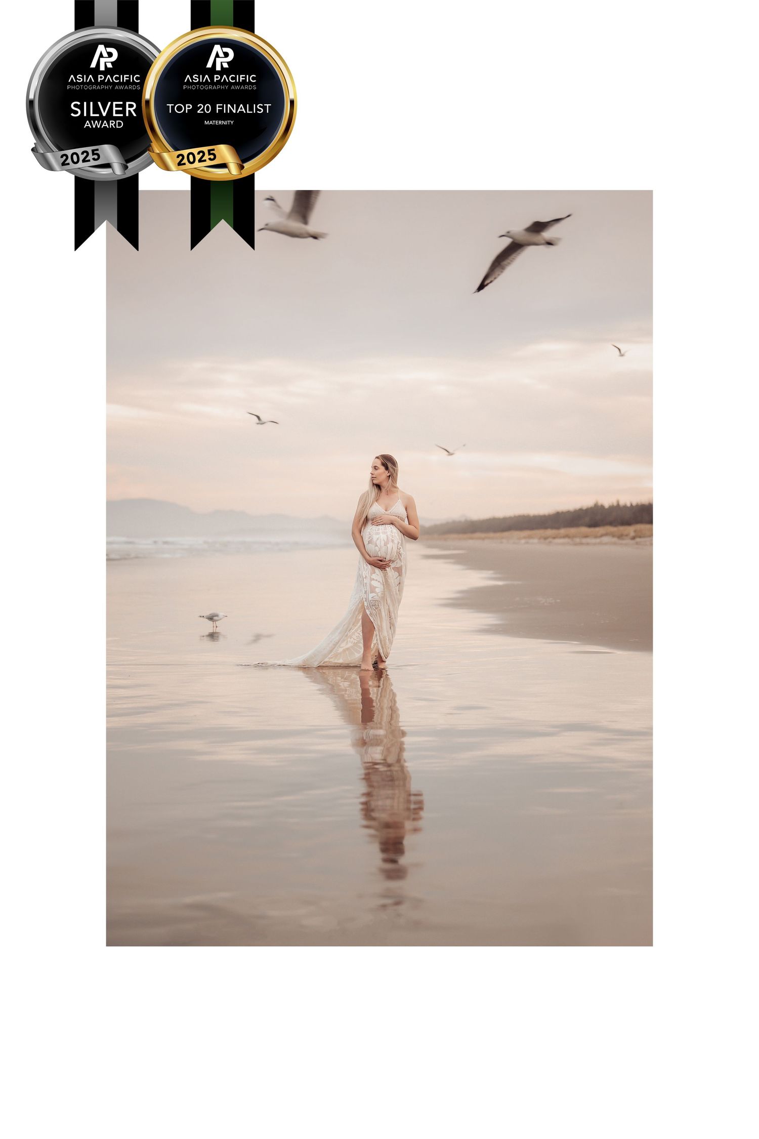 Award-winning ethereal maternity photo captured at sunset on a serene beach with seagulls flying overhead.