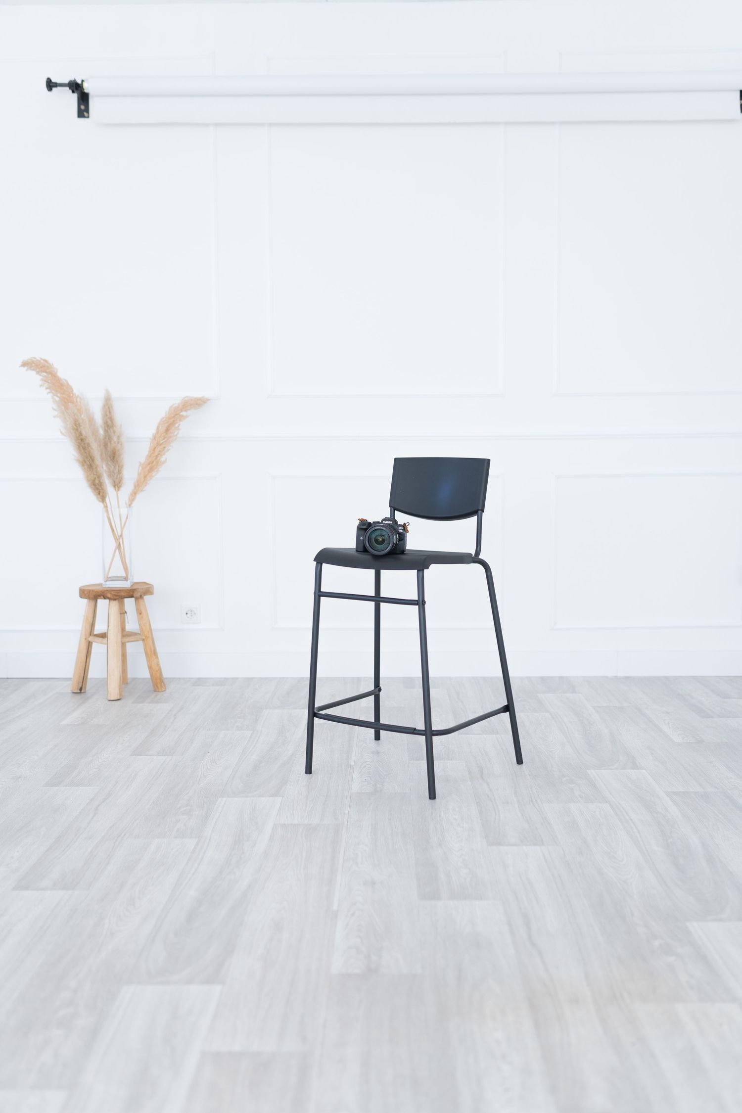Black modern dining chair shown from multiple angles on light gray wood flooring with minimalist decor.
