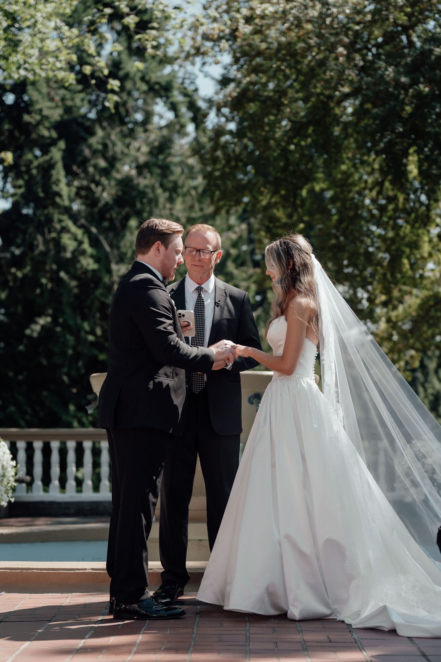 A wedding ceremony progresses through five photos showing an outdoor exchange of rings and vows between a couple in formal attire.