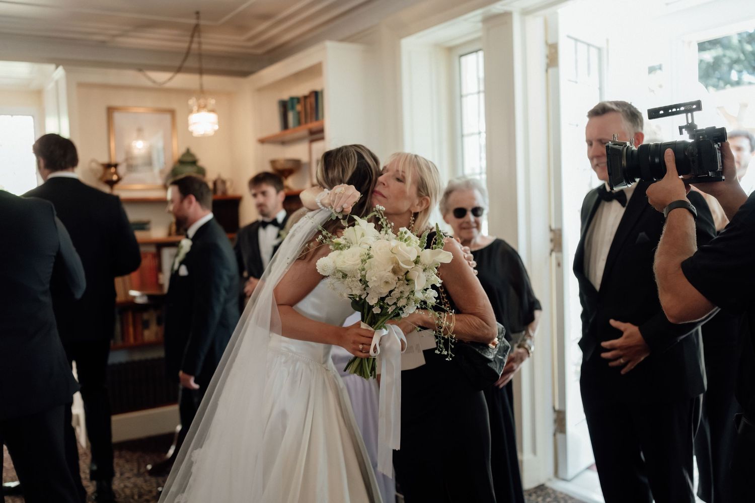 Wedding celebration in elegant indoor venue with guests and photographer.
