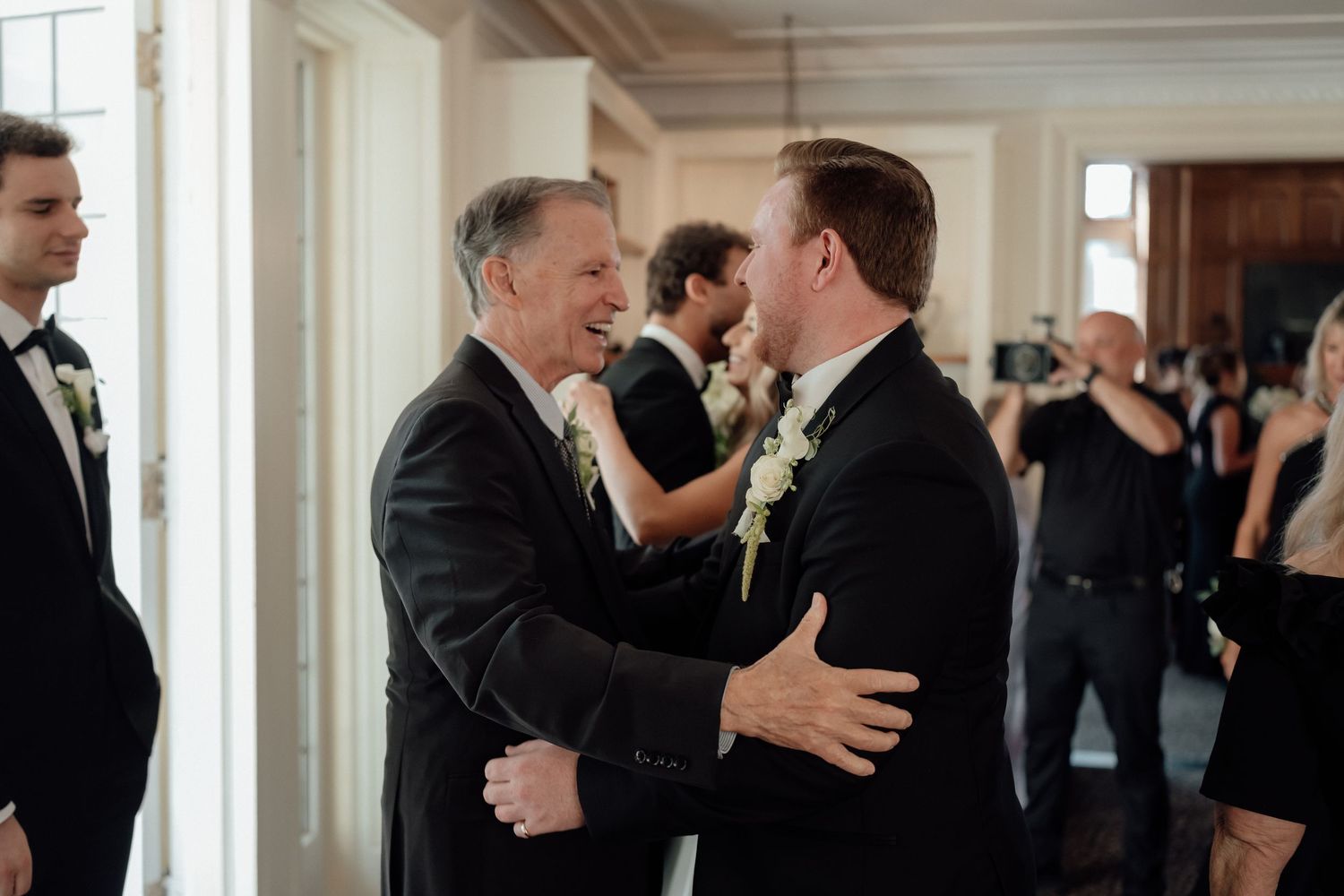 Emotional moment shared between guests during indoor wedding celebration.