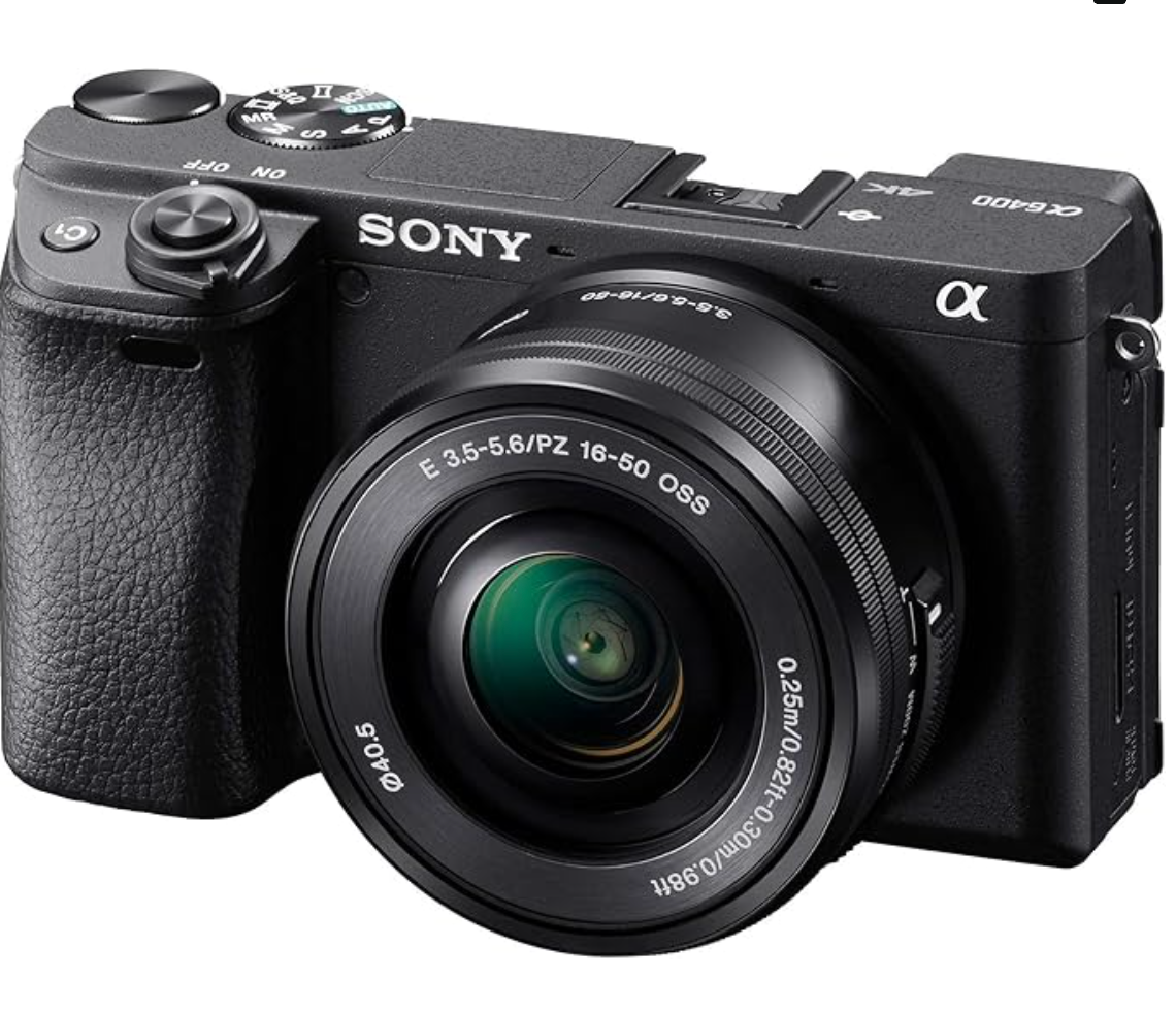 Sony Alpha mirrorless digital camera with black body and mounted 16-50mm lens showing green lens reflection.