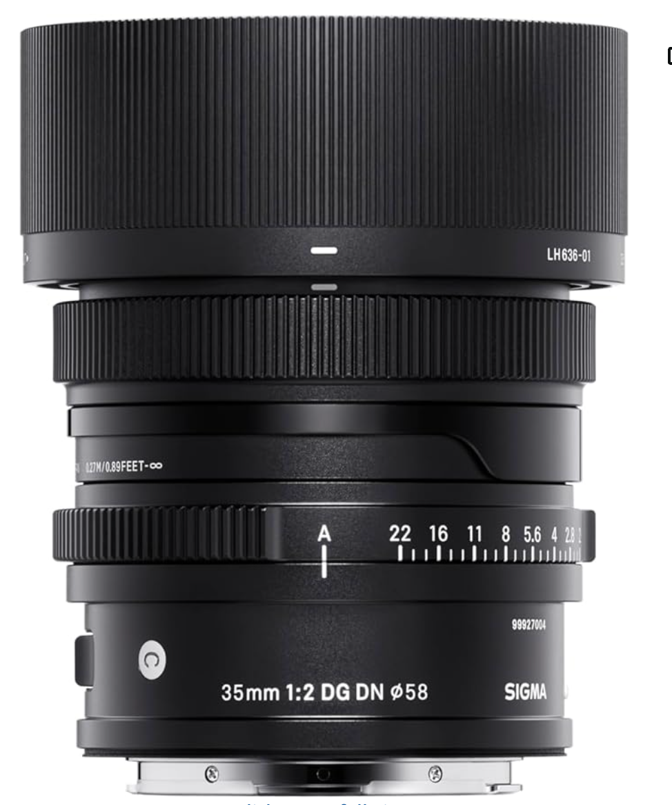 Black camera lens barrel shows aperture ring and focus markings in a close up studio product photograph.