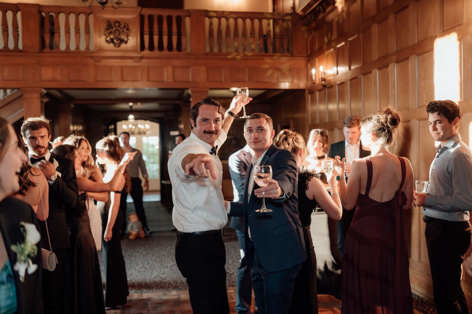 Wedding reception celebration in a rustic wooden barn with dancing guests.