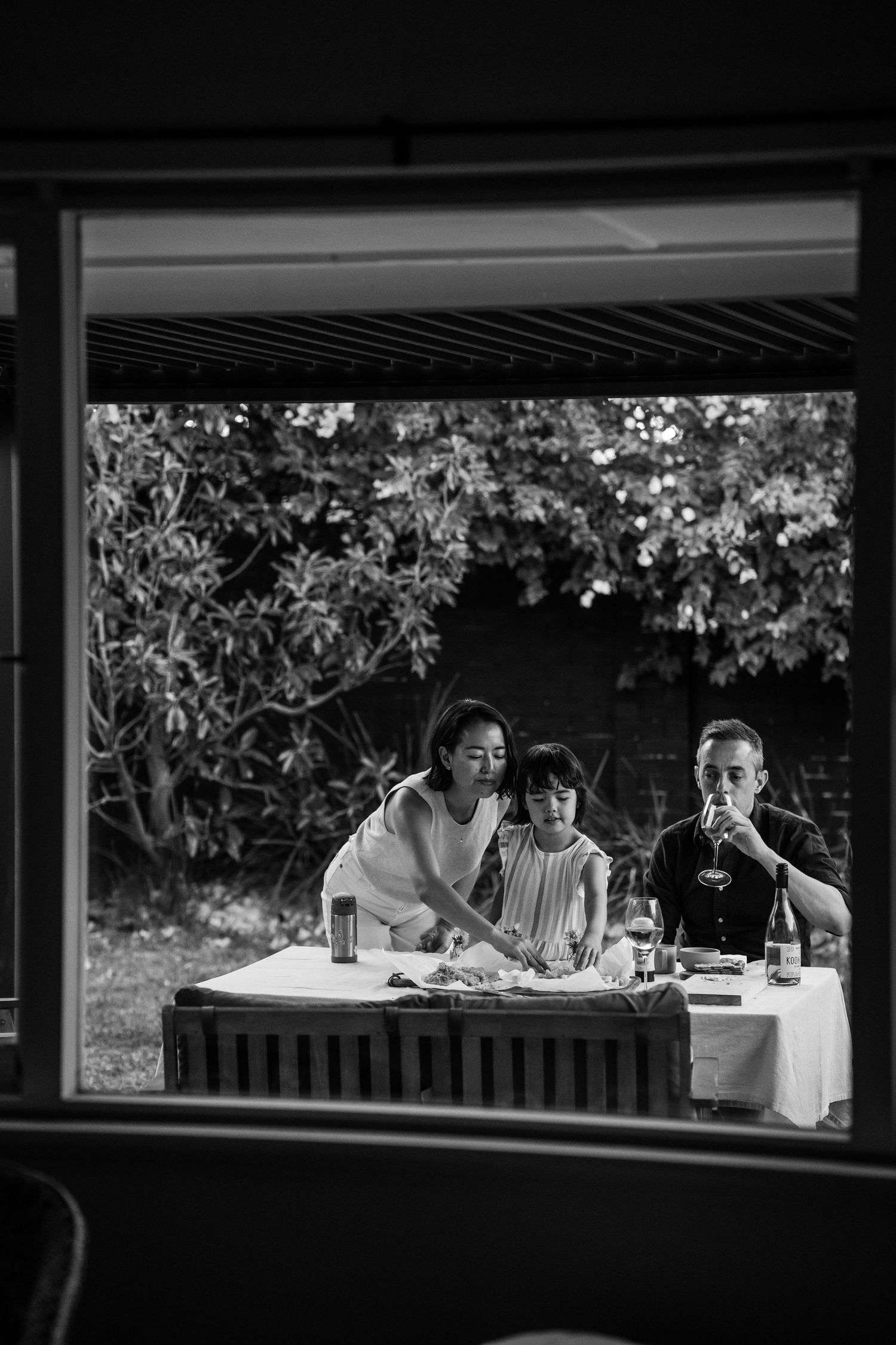 A Japanese mum, Irish dad and autistic daughter eating fish and chips on their back table.