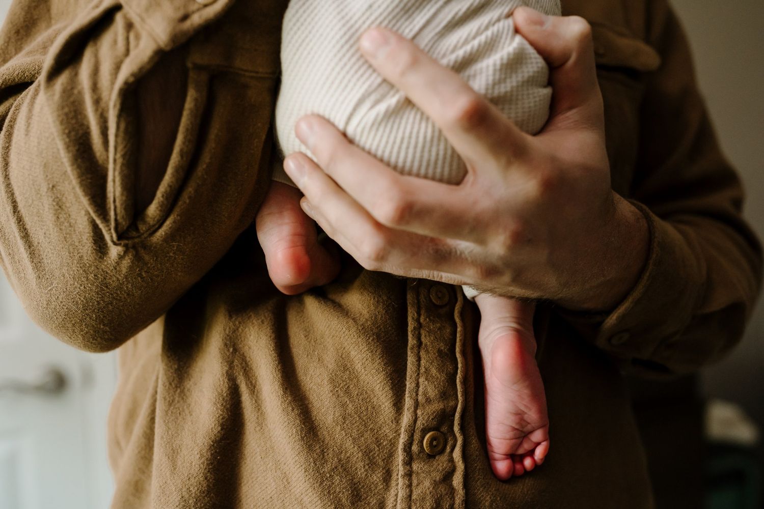Newborn baby feet in dad's hands