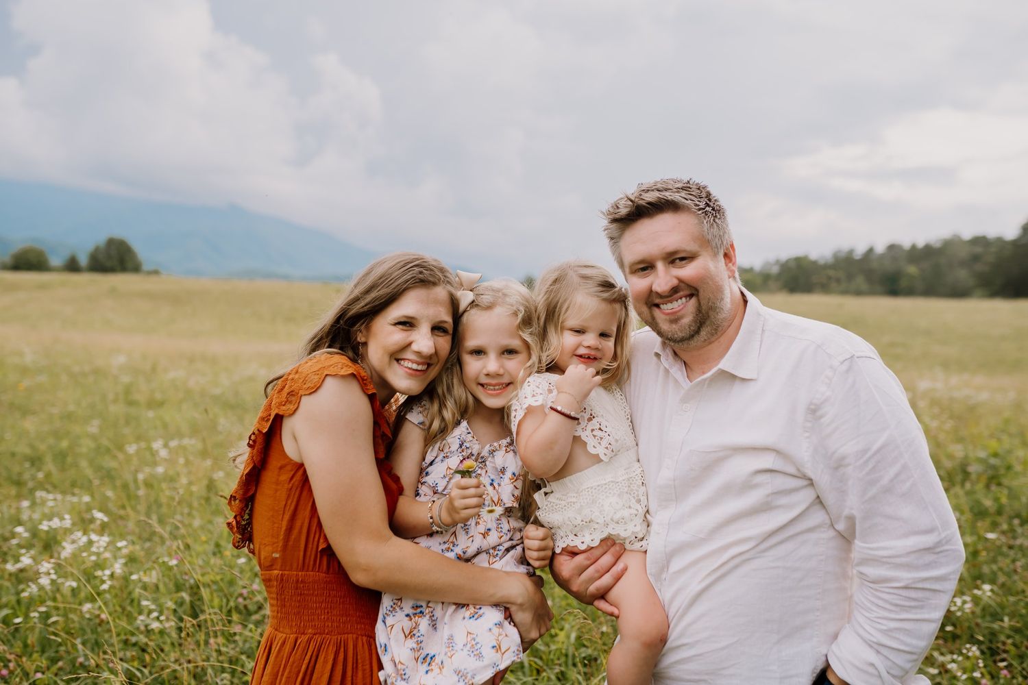 Family with young children smiles at camera during cades cove photography session