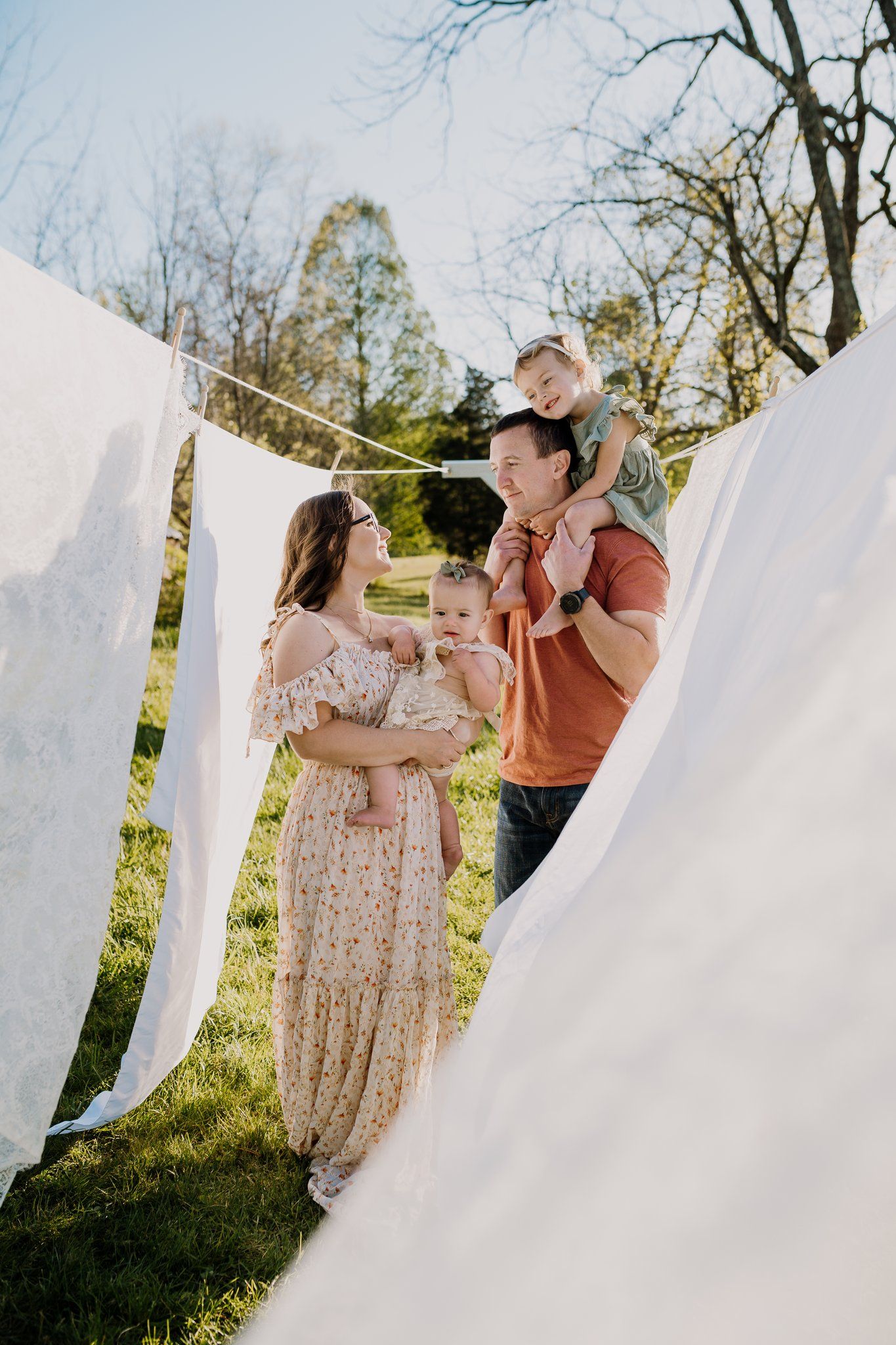 Family stands under clothesline at the holmstead studio for family photos in Karns