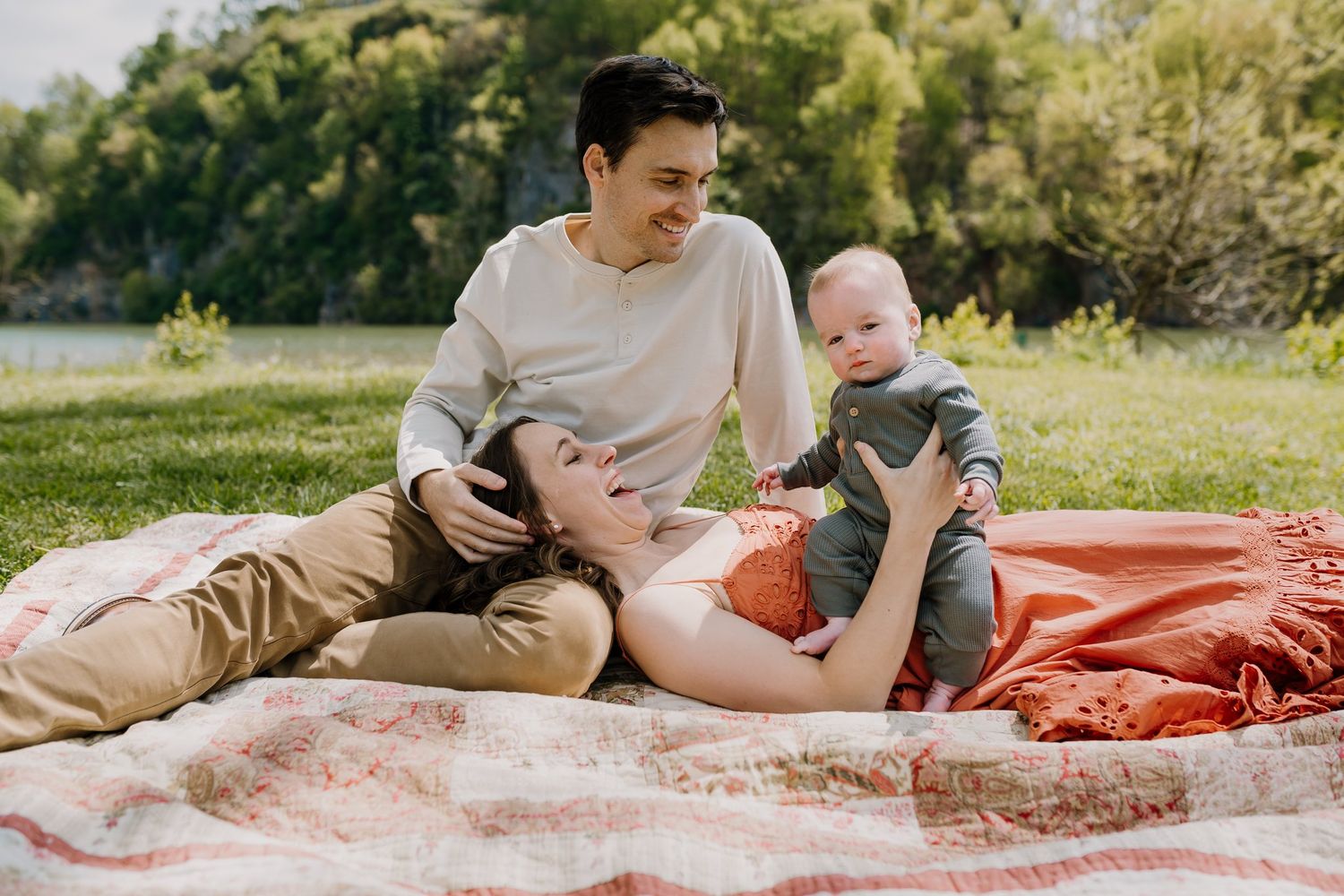 Parents sit on a blanket in Knoxville and play with their baby