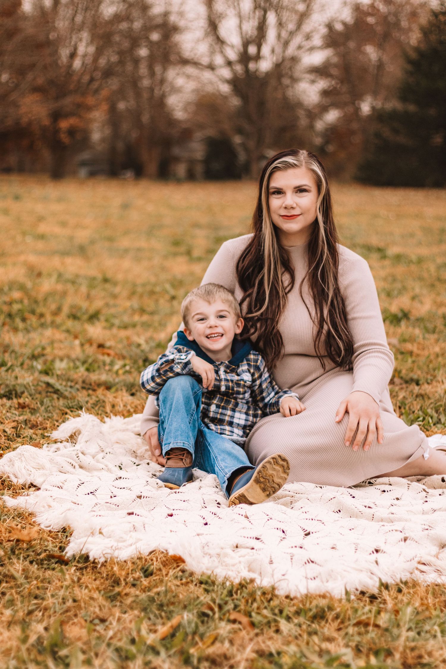 mother and her son posed on a blanket in the fall