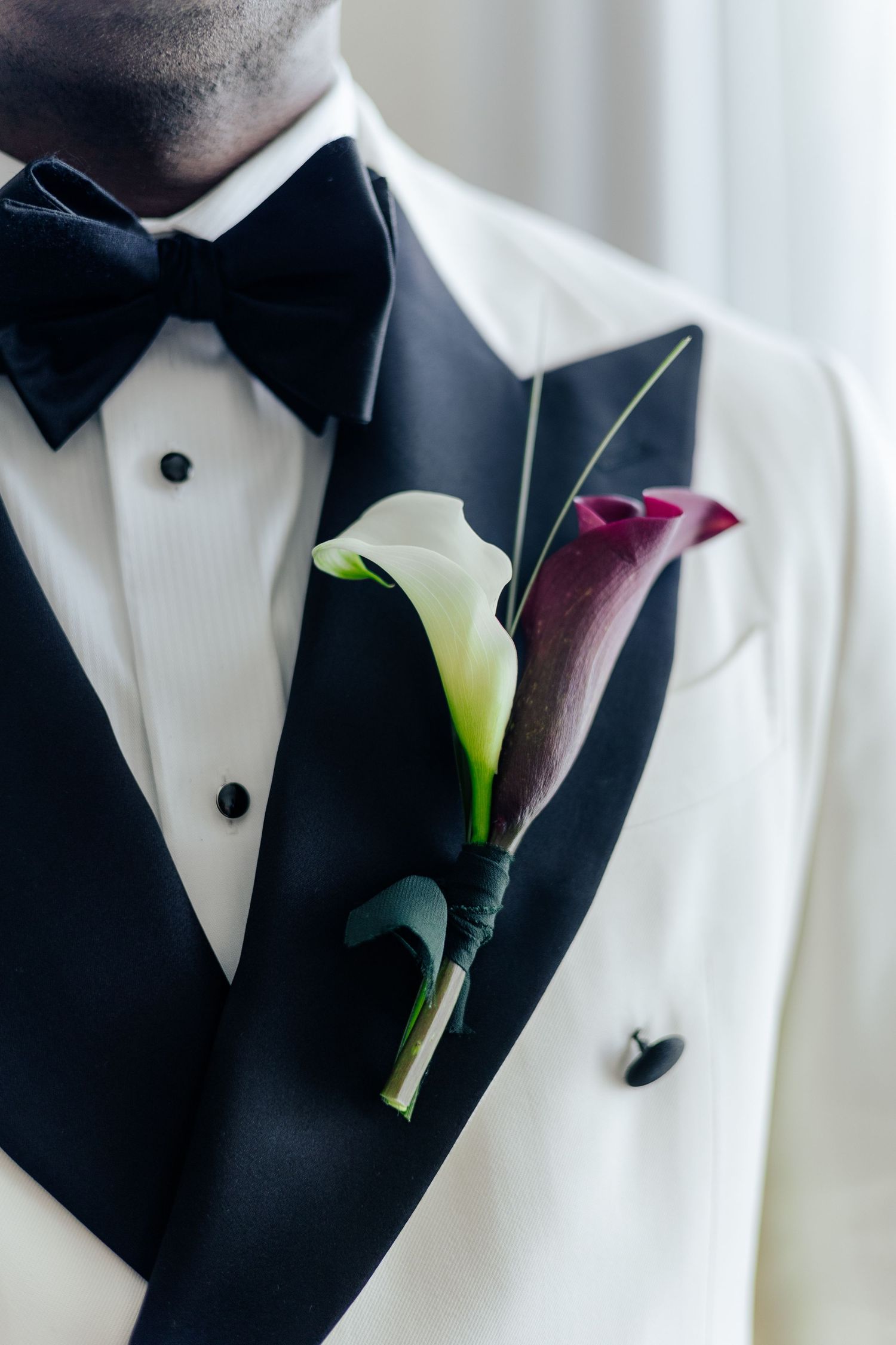 Elegant black tuxedo lapels with white calla lily boutonnieres arranged in a stylish wedding detail collage.