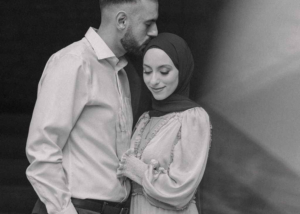 Romantic black and white portrait of a couple wearing traditional Muslim attire.
