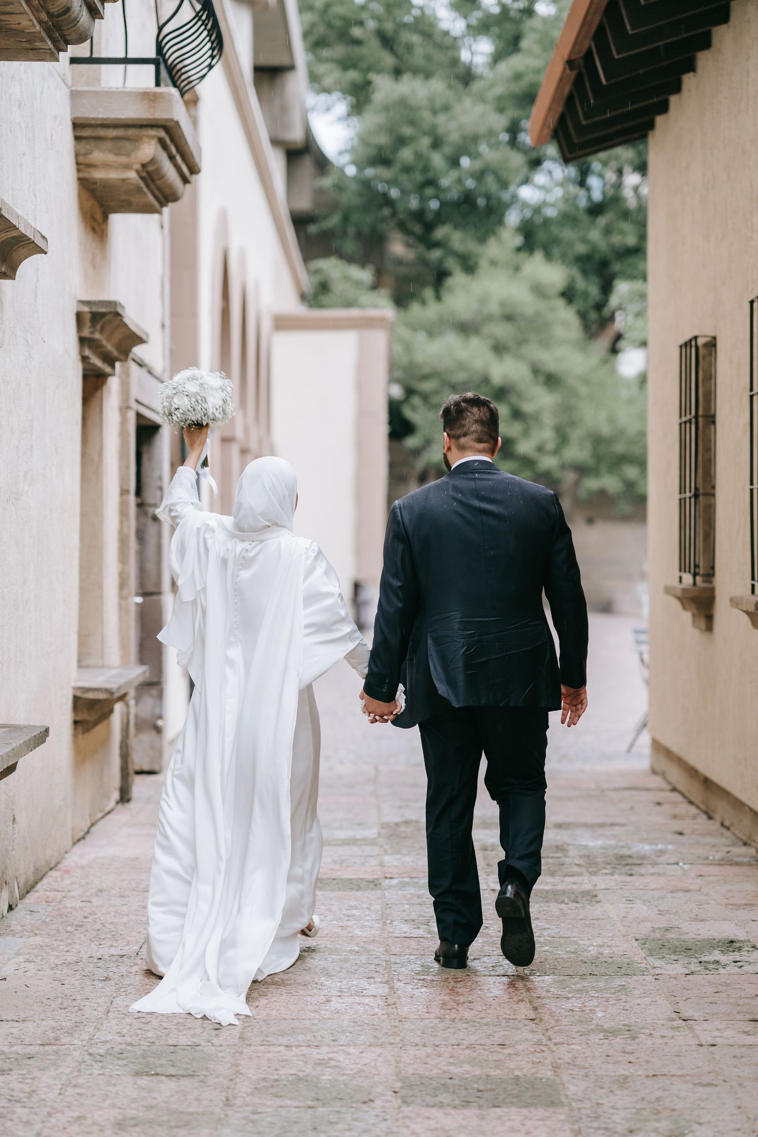 Dallas bride and groom walking away after their wedding while the bride holds a bouquet of flowers.